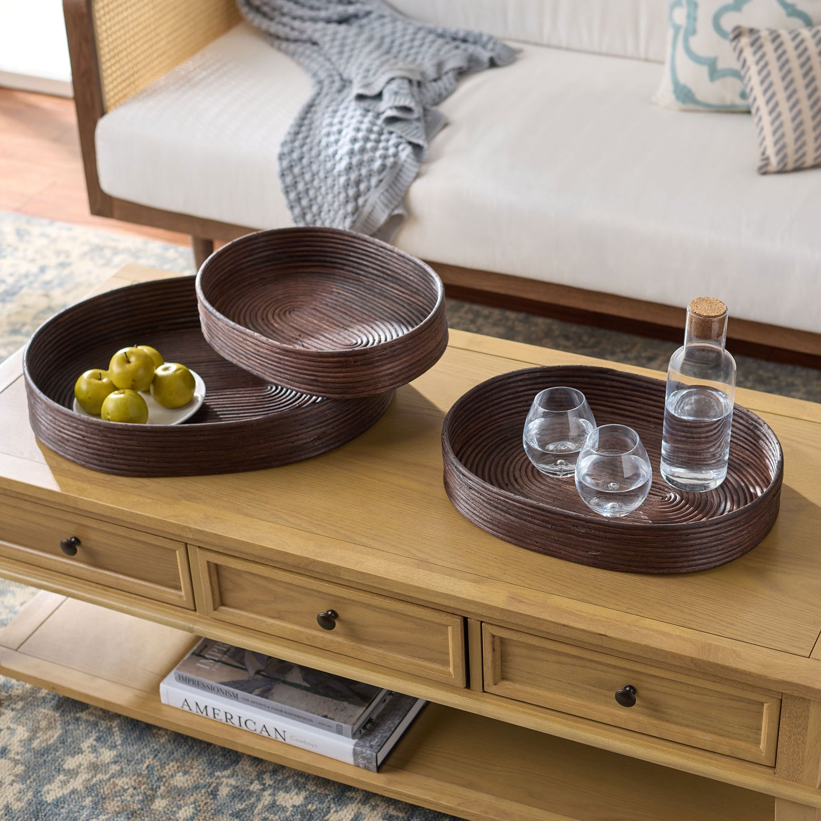 Three dark brown rattan trays keep fruit and drinks organized on a living room coffee table || STG1818A || front_angle_room