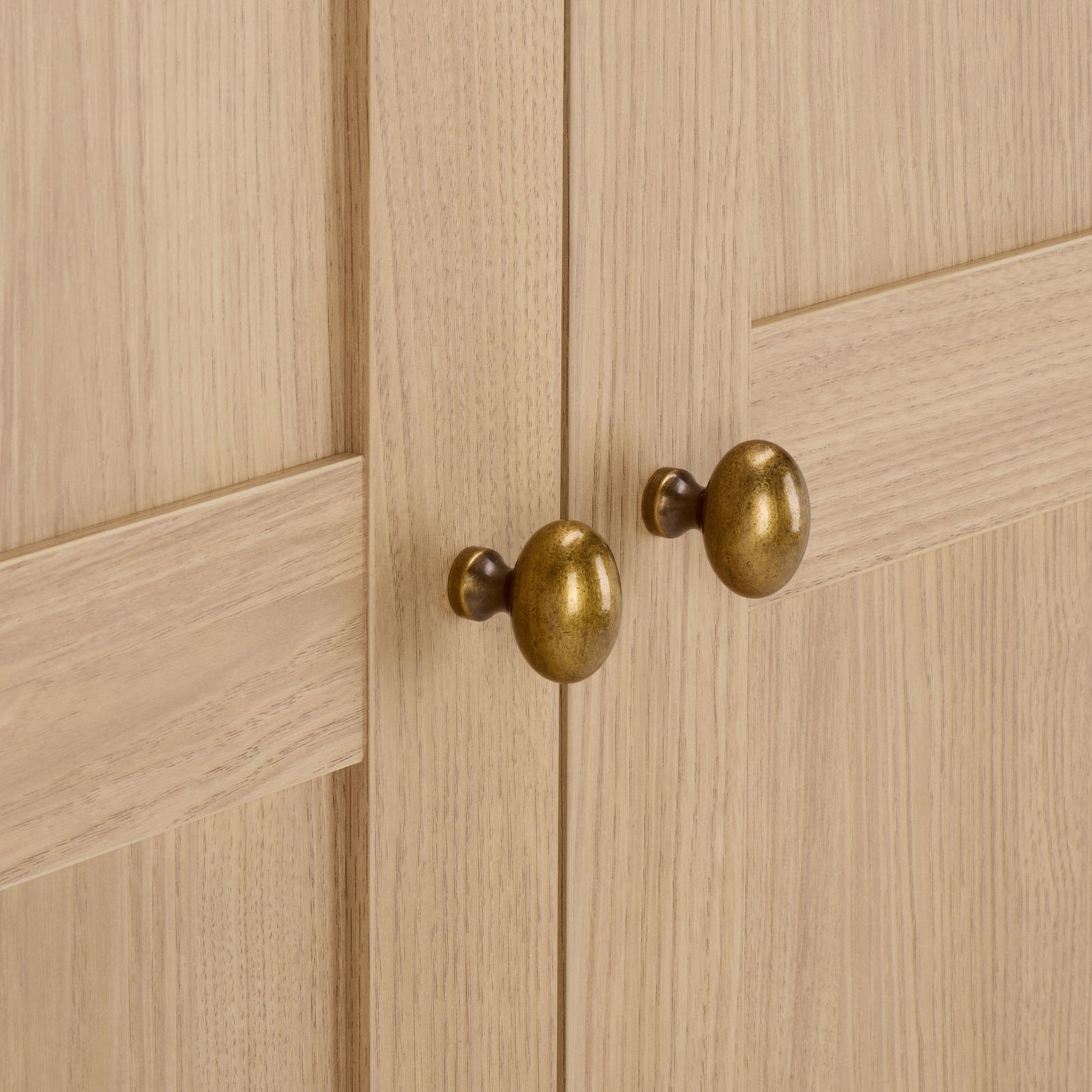 Rounded brass-tone knobs stand out against the natural wood-look panels. || STG3102B-2BX || handle_studio