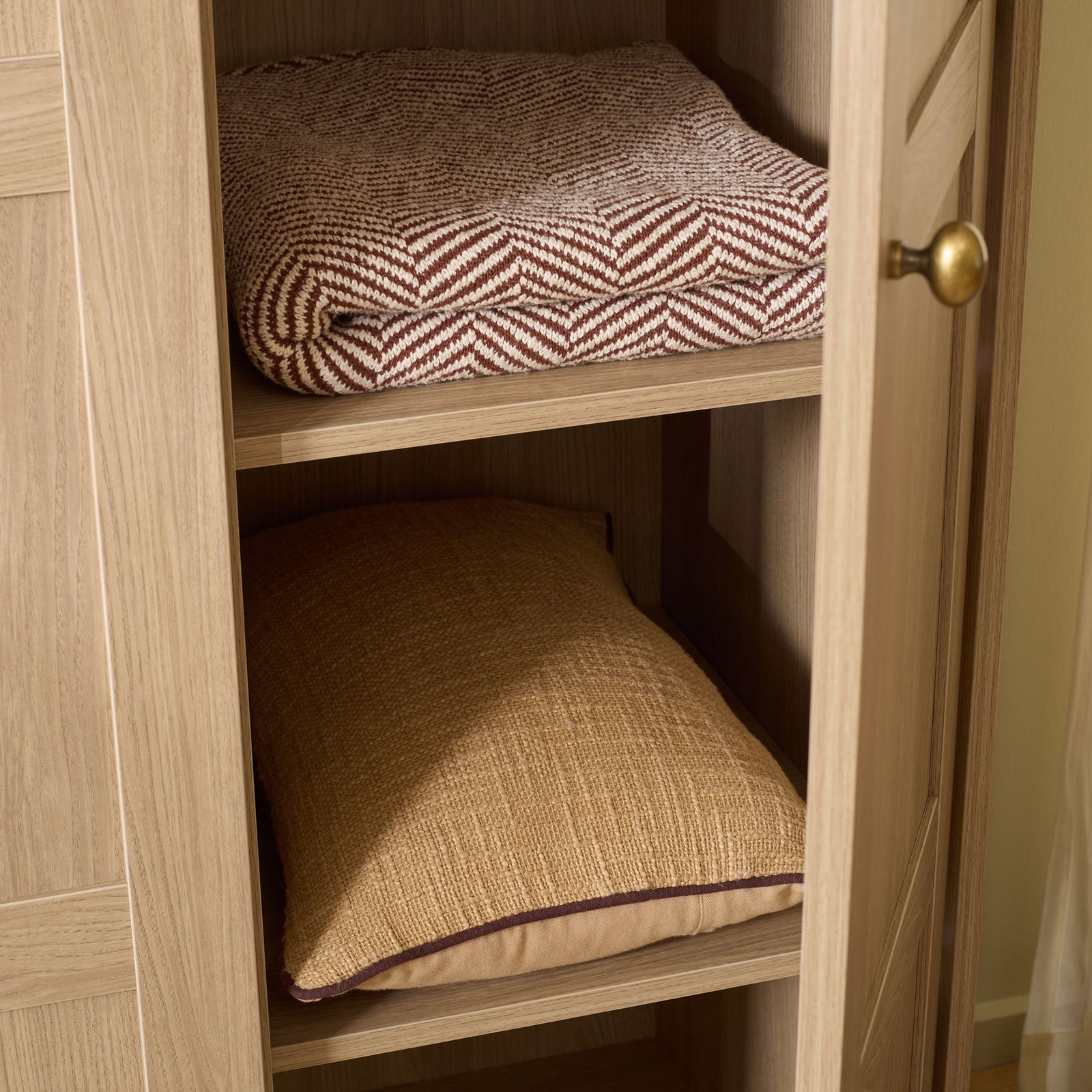 Natural wood-look shelves hold folded bedding behind an open paneled door. || STG3103B-3BX || storage_open_room