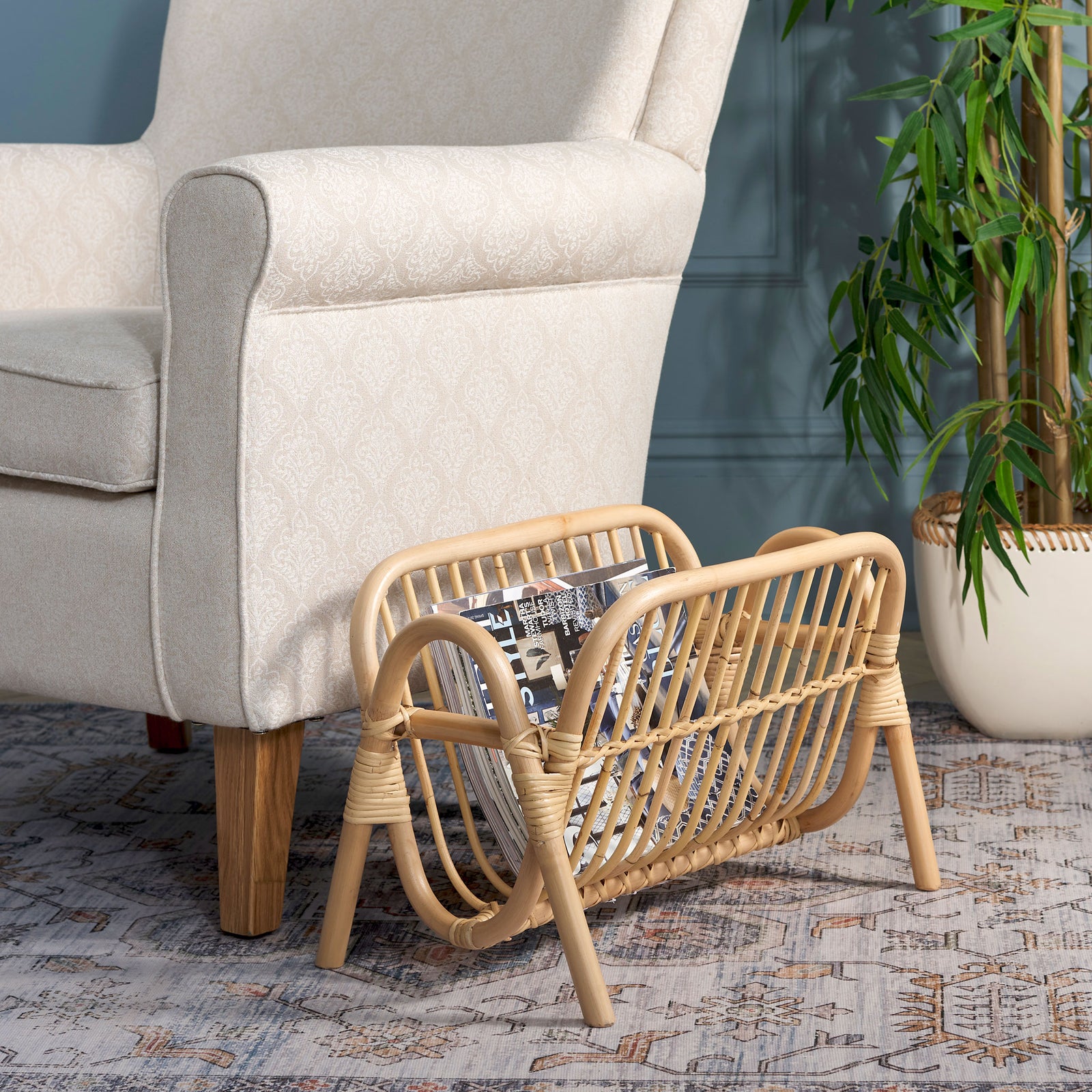 An open rattan rack holds magazines neatly beside a chair, creating an inviting reading spot. || STG6505A || front_angle_room