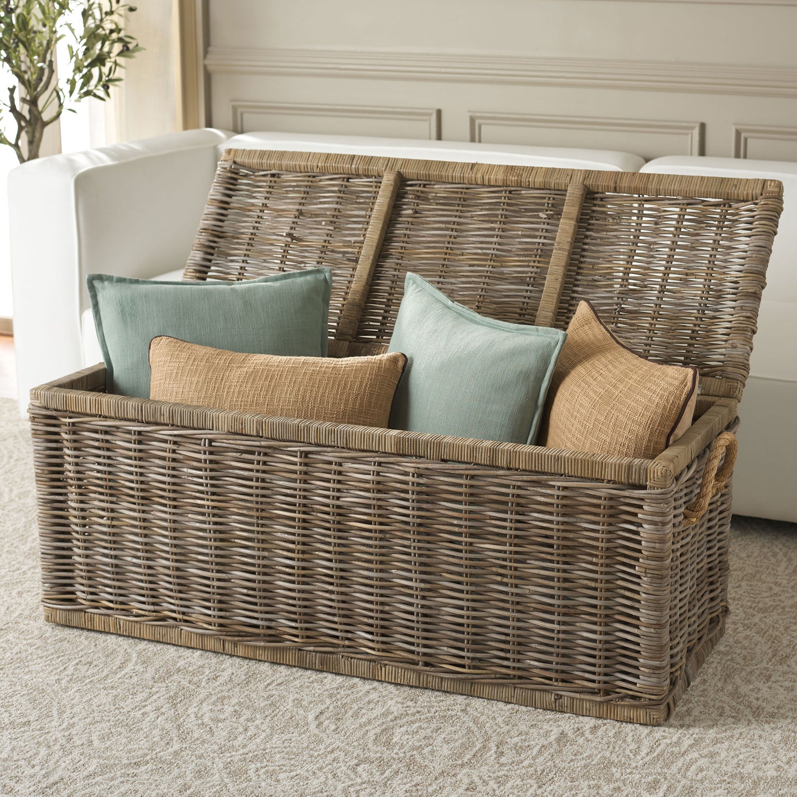 An open woven trunk keeps pillows close at hand beneath a hinged rattan lid. || STG6506A || front_angle_open_room