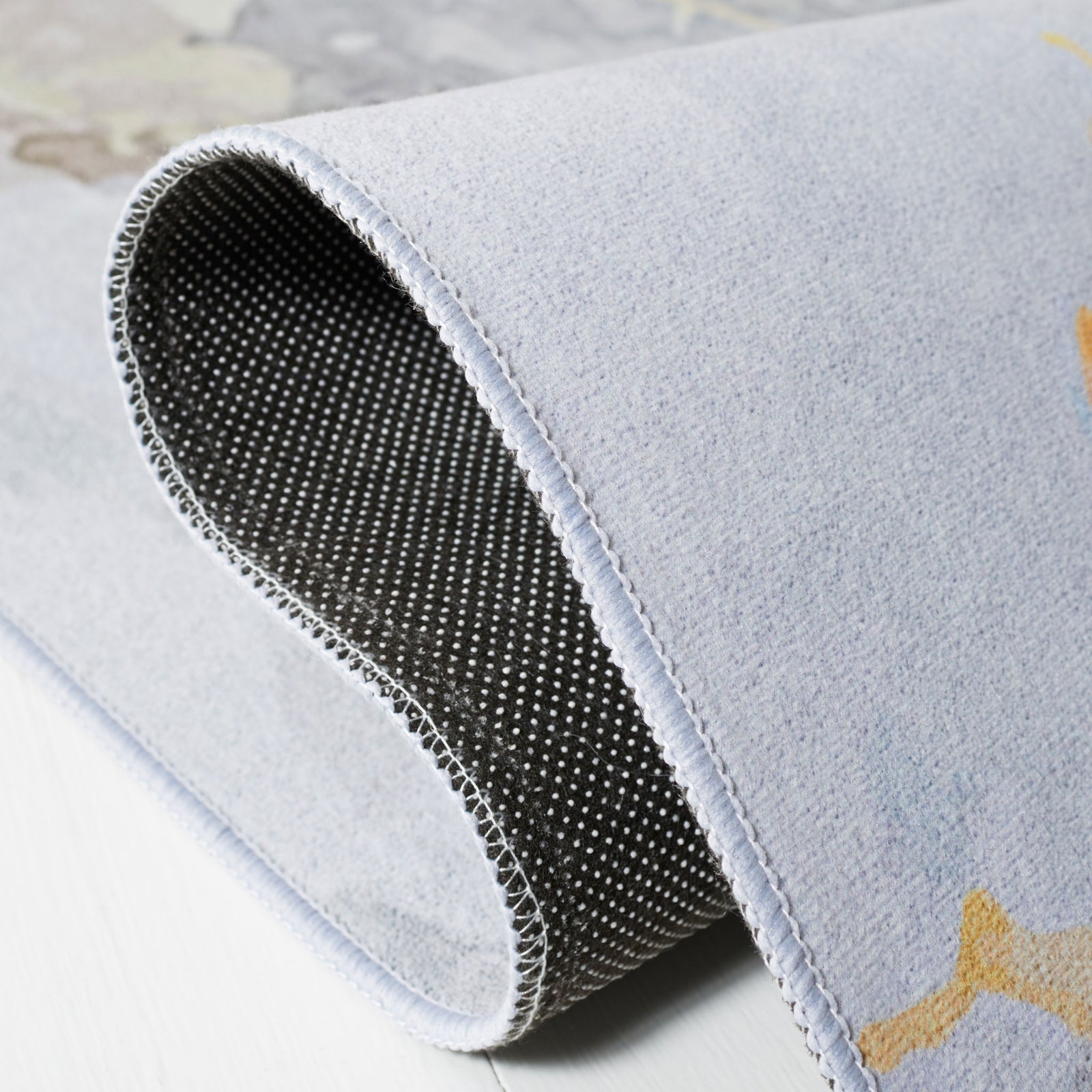 Folded corner reveals slip-resistant dotted backing and smooth, flexible pile || TAC811F-5 || backing_studio