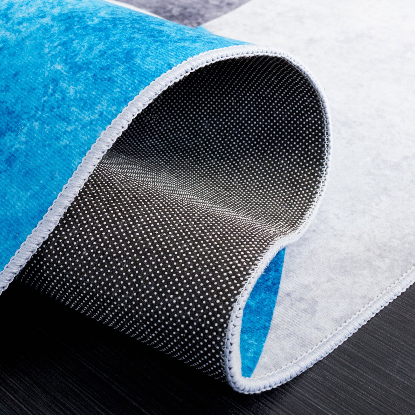 Curled corner reveals dotted non-slip backing and neatly serged edges || TAC837G-5 || backing_studio