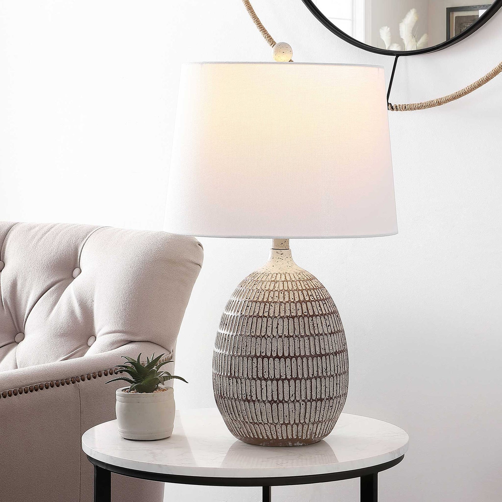Soft ambient glow highlights the textured brown-and-white resin base beneath the white shade || TBL4421A || front_angle_on_room