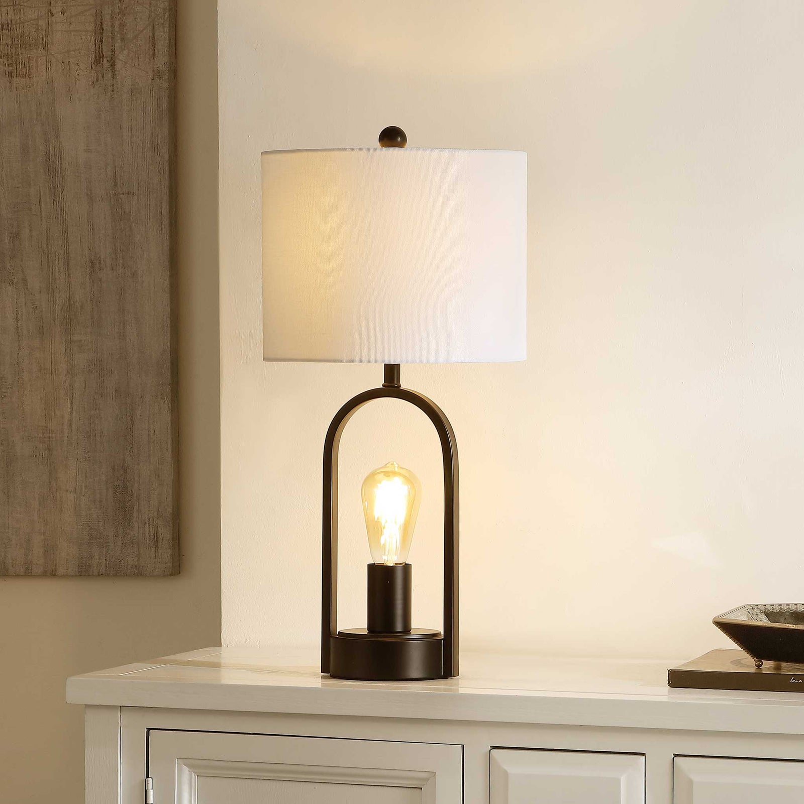 Warm glow highlights the black arch frame and soft white fabric shade || TBL4482A || front_angle_on_room
