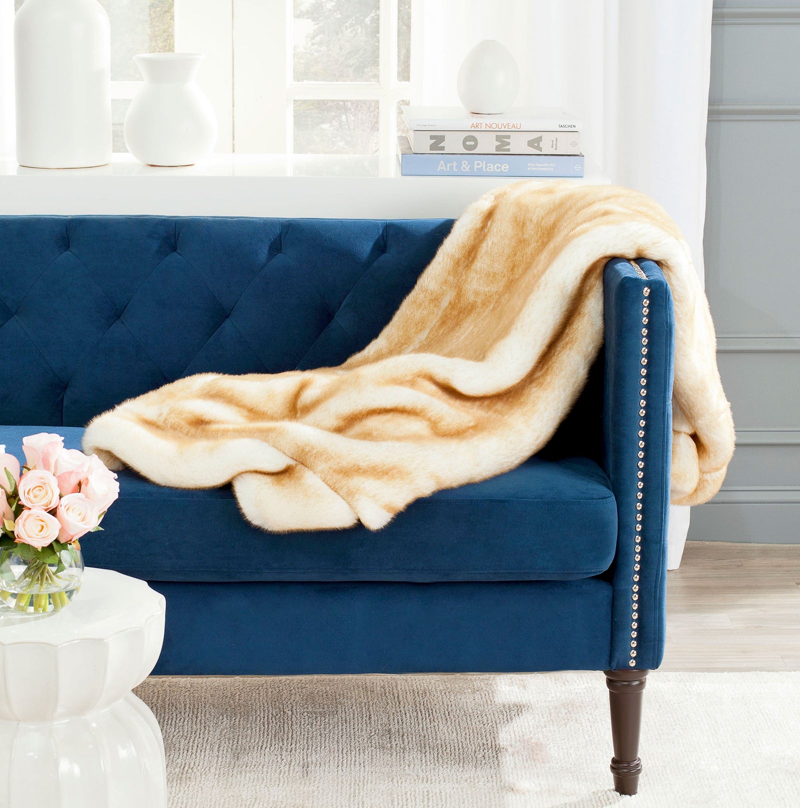 Soft faux fox fur drapes in warm cream and tan folds over a sofa. || THR702A-5060 || front_room