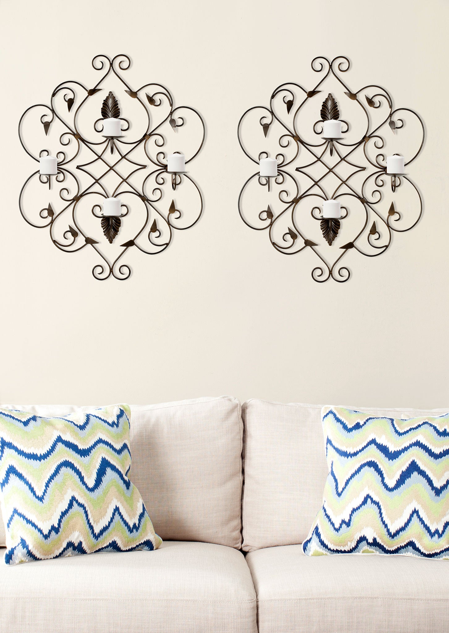 Two rust-finished wall accents pair scrolling ironwork with four white candles apiece. || WDC1004A || front_room