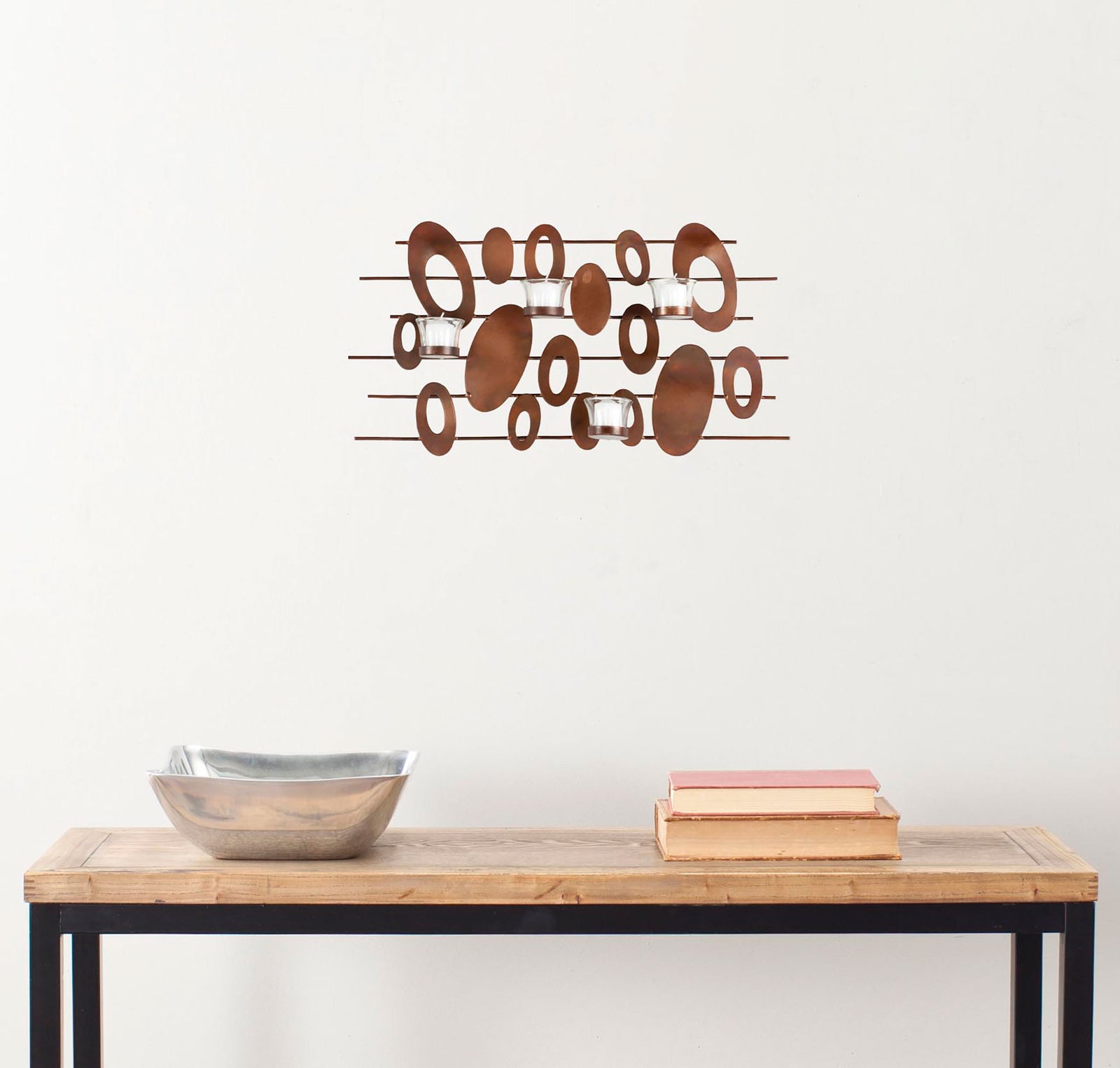 Sculptural rust-toned ovals bring organic movement to an iron wall accent with clear glass votives. || WDC1015A || front_room