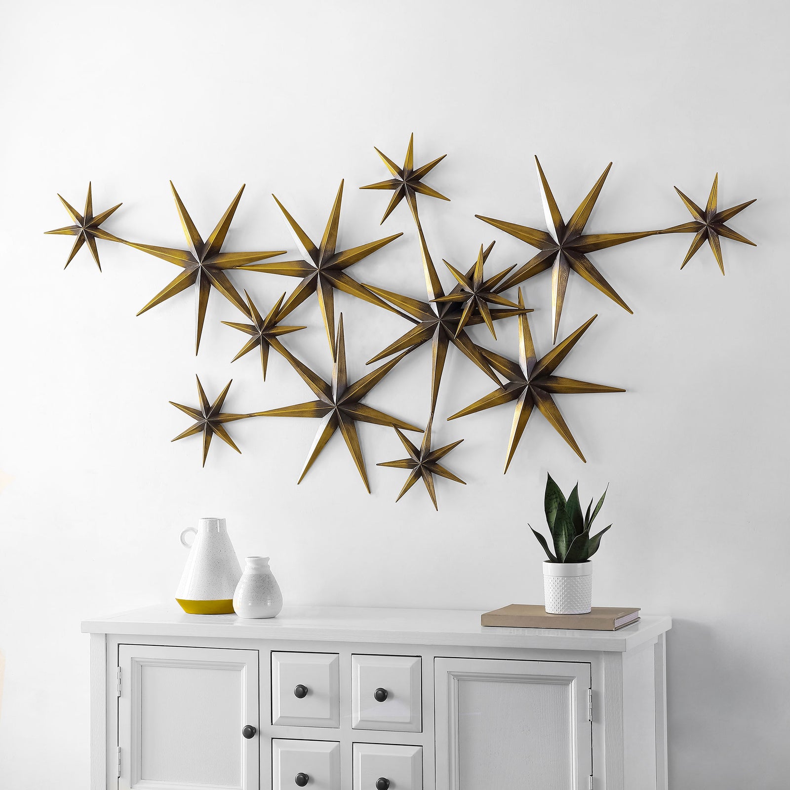 Clustered bronze starbursts bring warm metallic sparkle to the wall above a white cabinet. || WDC5021A || front_room