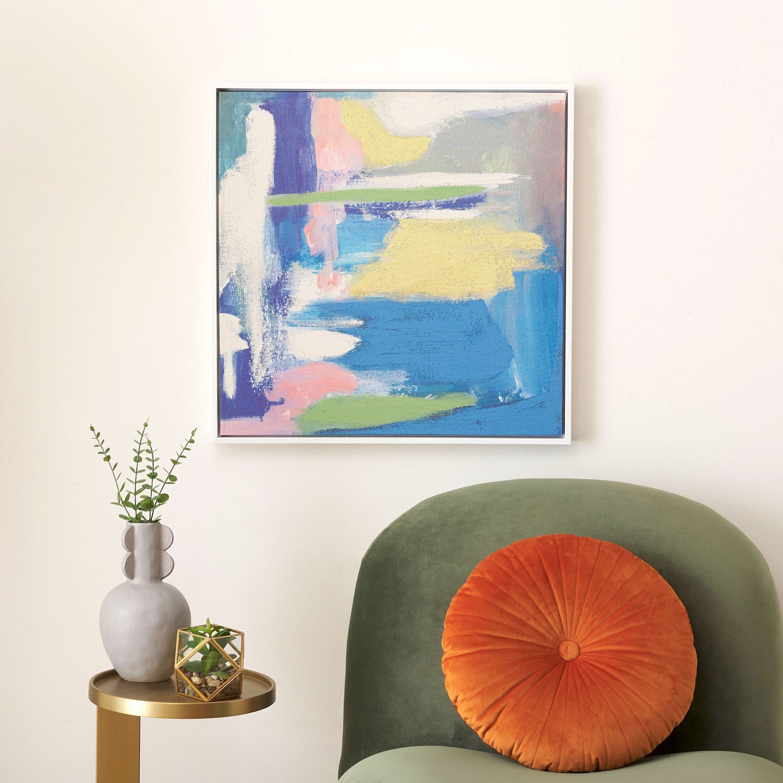 Soft blue, yellow, pink, and green abstract art adds color above a green chair. || WLA2080A || front_room