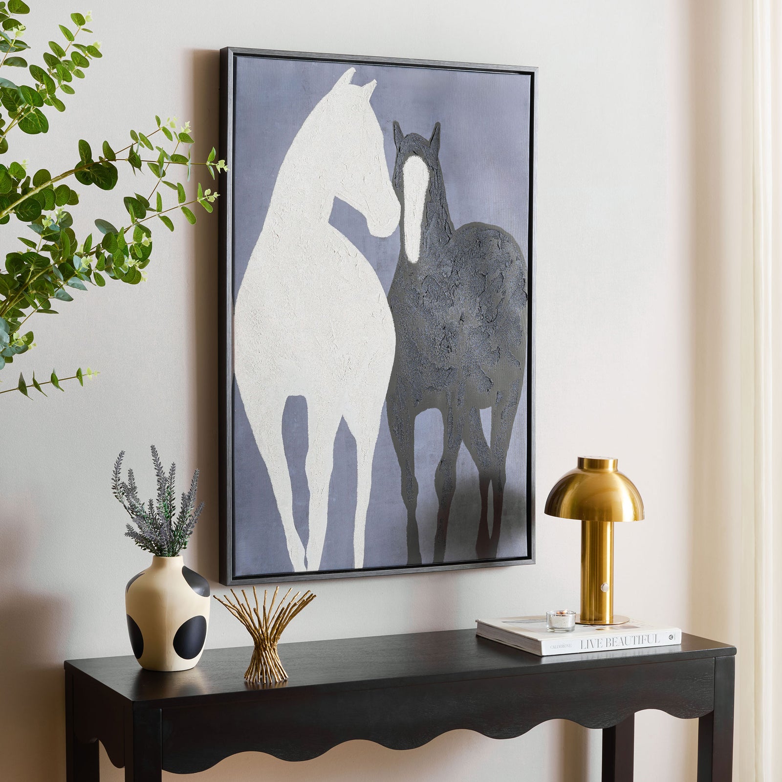 White and charcoal horses lend bold contrast to a muted blue-gray canvas above a black console table. || WLA3027A || front_angle_room