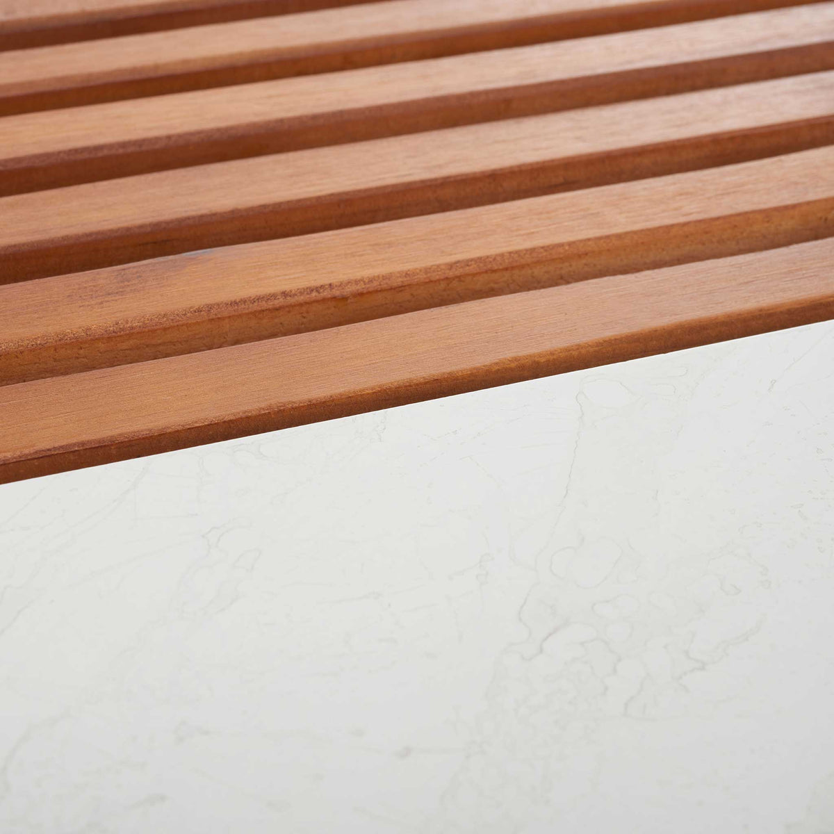 Warm-toned slatted wood pairs with crisp white faux marble for a striking finish