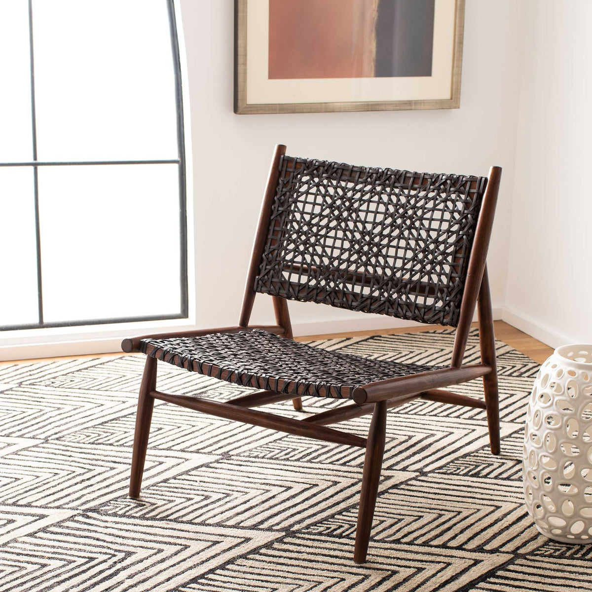 Dark woven leather and a brown wood frame add graphic texture to a relaxed seating area.