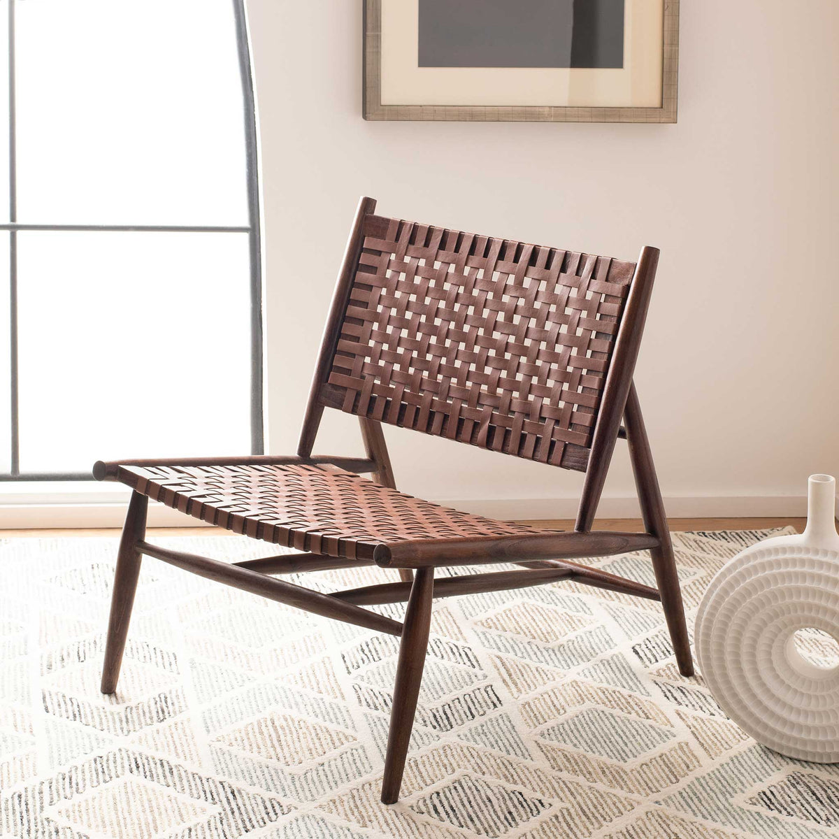 Cognac woven leather warms a dark wood chair with an easy, low-slung silhouette