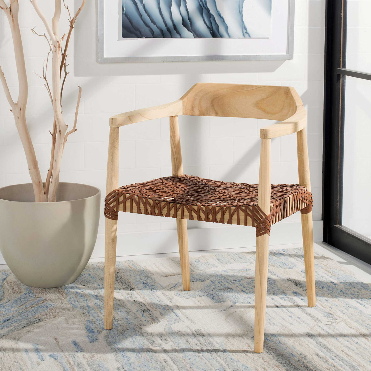A light wood frame and warm brown woven seat lend relaxed texture to a sunny space