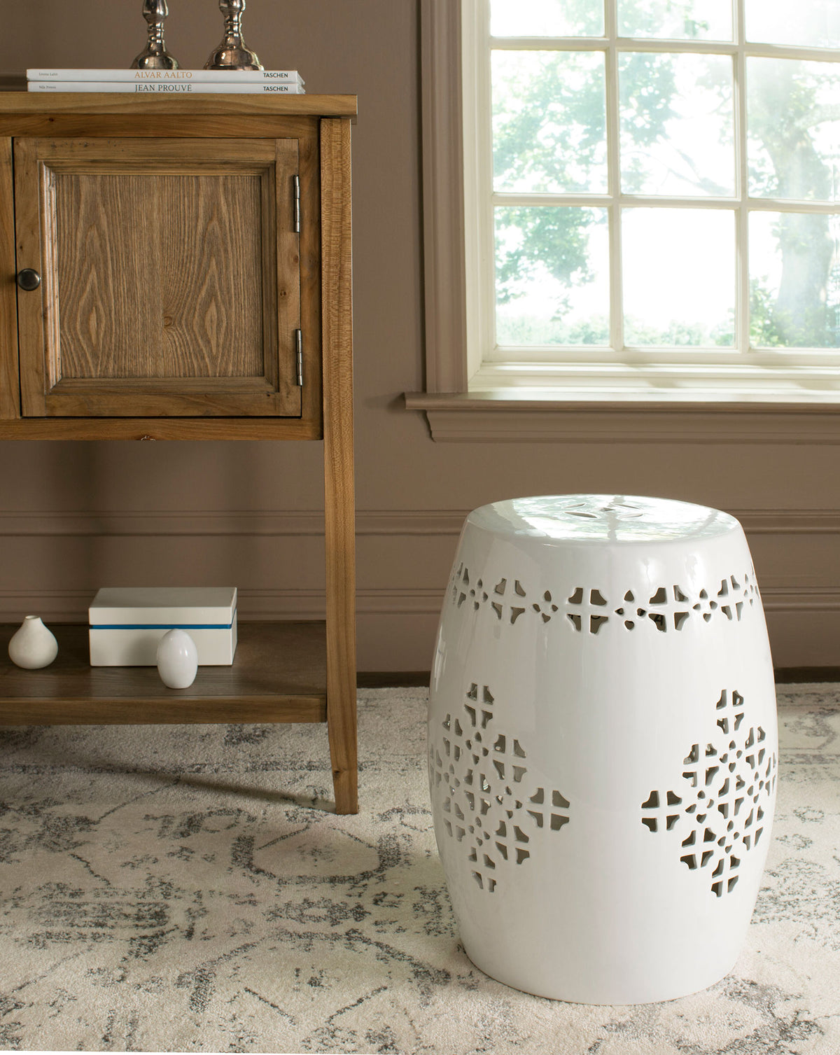 Antique white ceramic garden stool with a rounded silhouette and airy quatrefoil cutouts