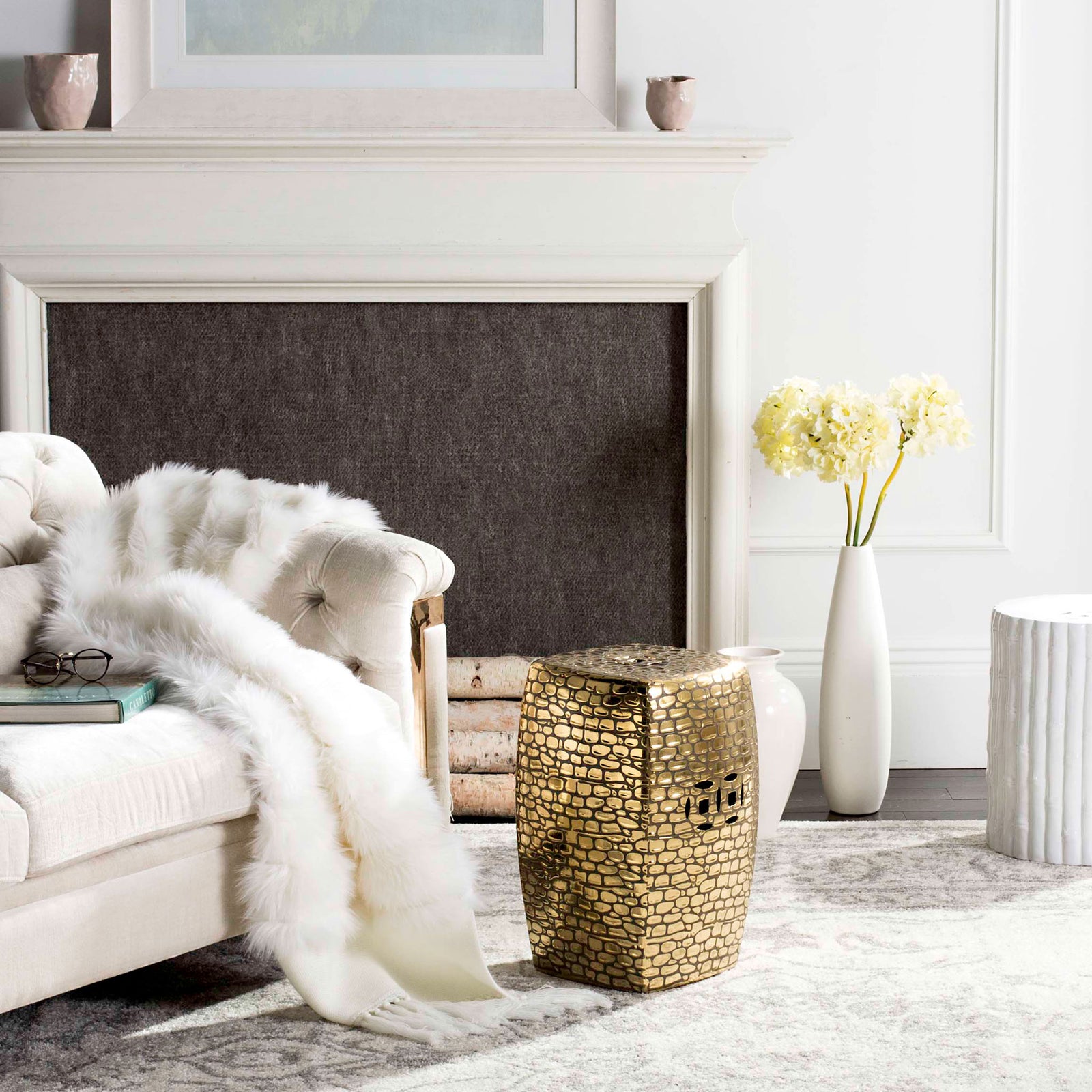 Gold ceramic garden stool adds a patterned metallic accent beside a plush sofa || ACS4544A || front_angle_room