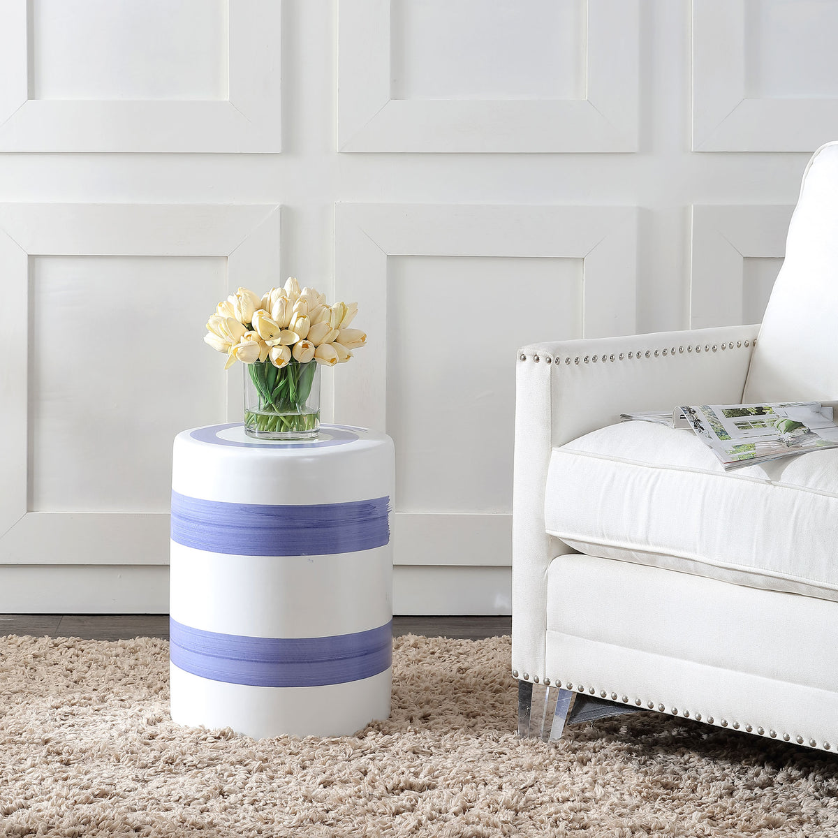 Blue-banded ceramic garden stool provides a stylish surface for flowers beside an armchair. || ACS4584A || front_angle_room