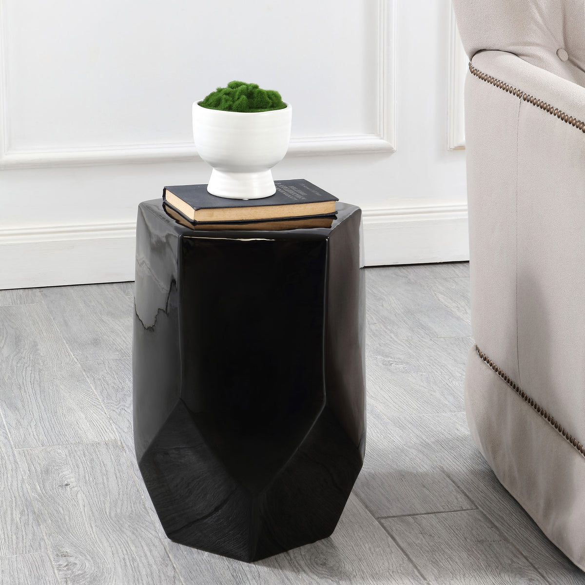 The faceted black ceramic stool doubles as a side table for books and a potted plant || ACS4596B || front_angle_room