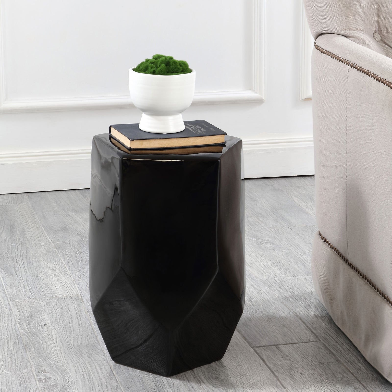 The faceted black ceramic stool doubles as a side table for books and a potted plant || ACS4596B || front_angle_room