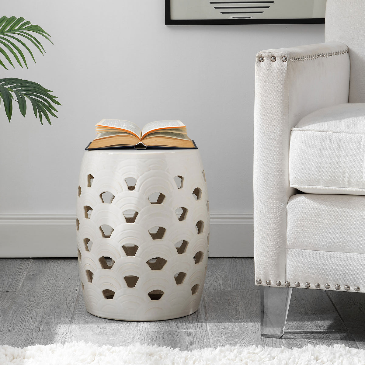 Cream openwork stool serves as a side table beside an upholstered chair. || ACS4597A || front_room
