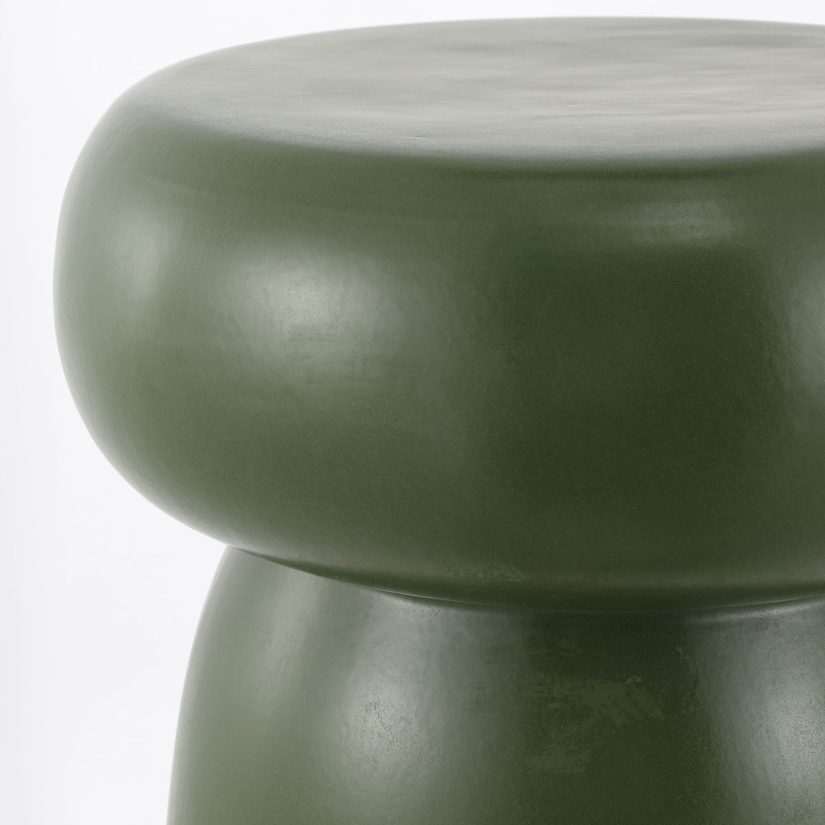 The moss green ceramic stool's rounded top gleams softly above a sculpted waist. || ACS4598C || detail_studio