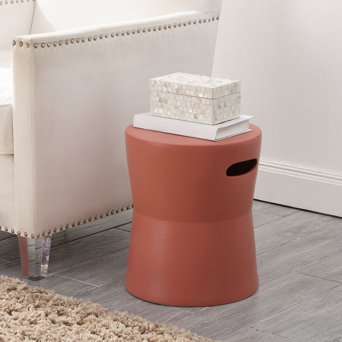 Terracotta ceramic stool provides a colorful side table beside an upholstered chair || ACS4599B || front_angle_room