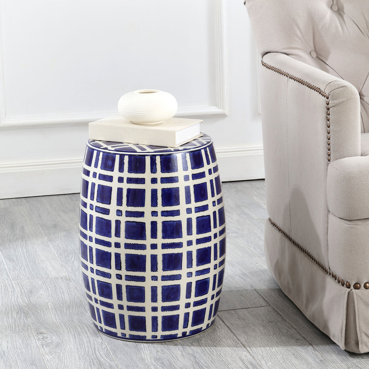 A navy and white ceramic garden stool adds a patterned accent beside a sofa and doubles as a side table