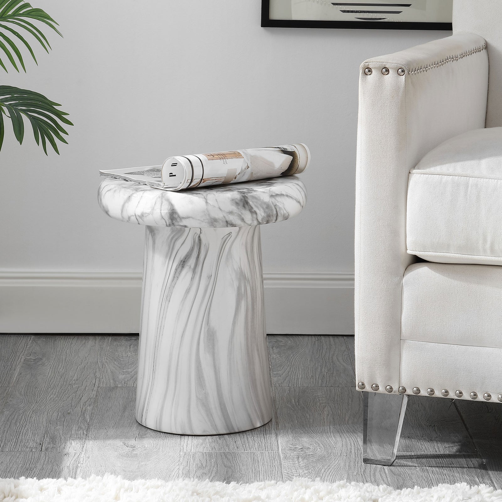 A white marble-look ceramic stool serves as a small side table beside an upholstered chair. || ACS4607A || front_room