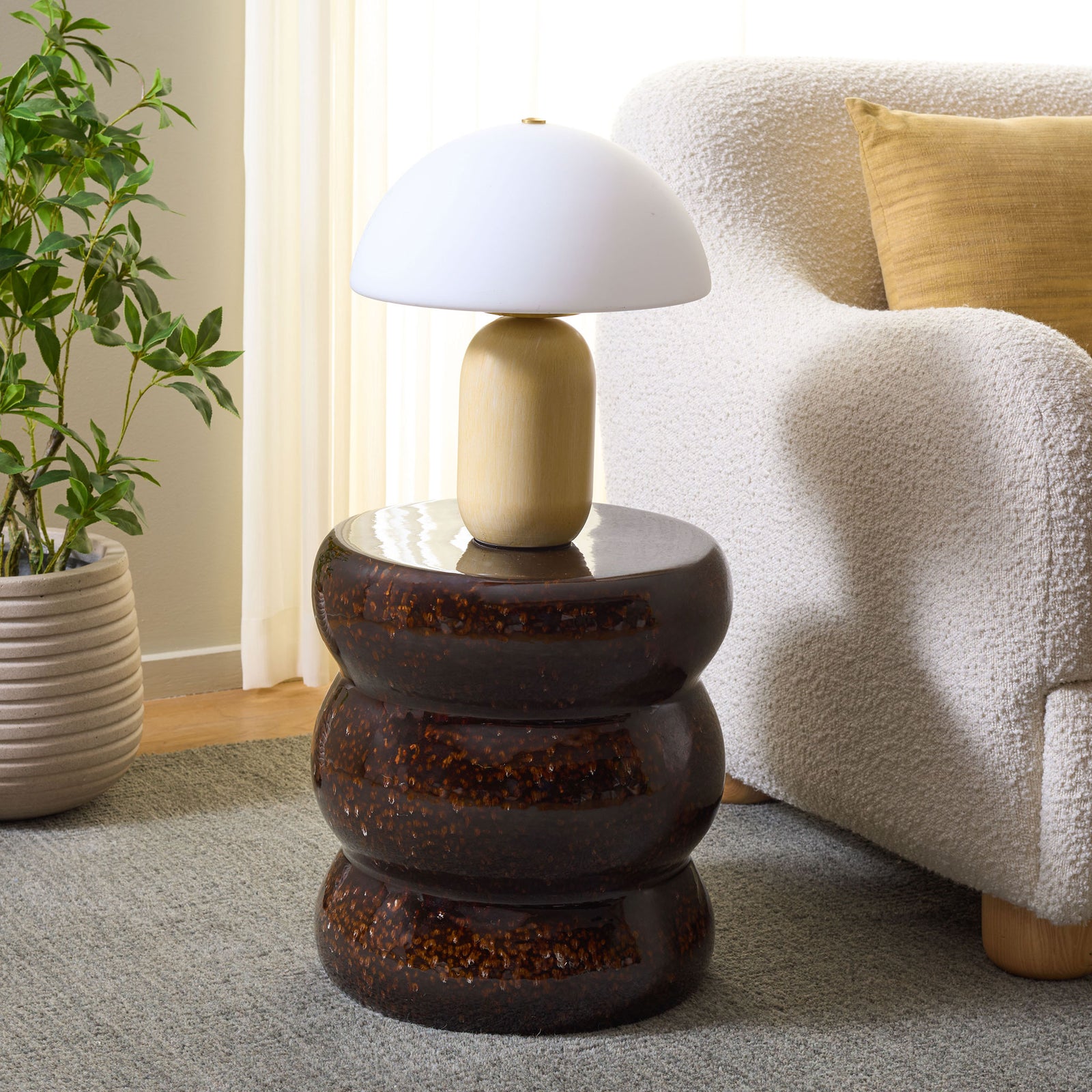 Sculptural brown ceramic stool doubles as a handy side table beside a cozy chair. || ACS4612B || front_angle_room