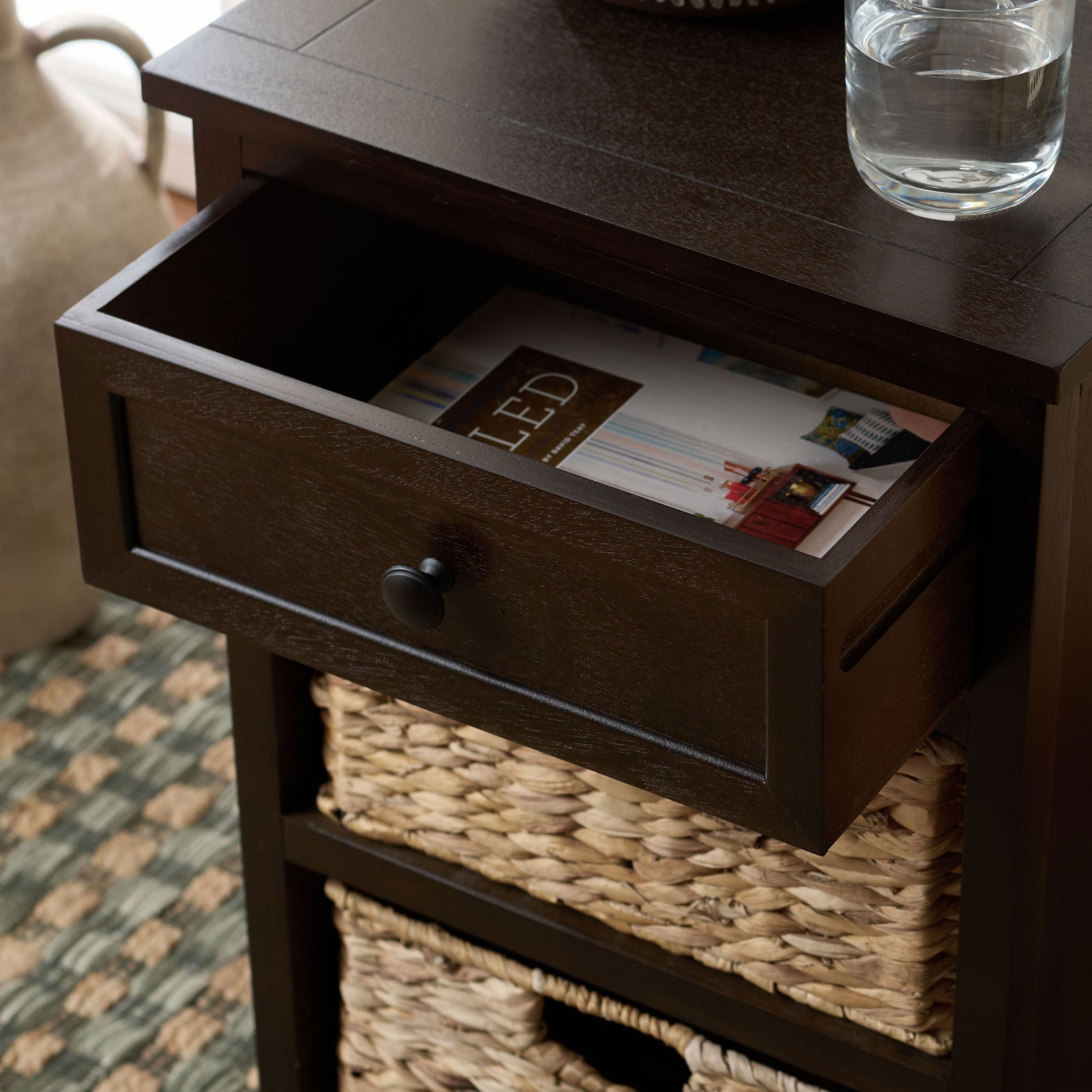 The dark brown drawer opens to hold everyday essentials above woven baskets. || AMH5700H || storage_open_room