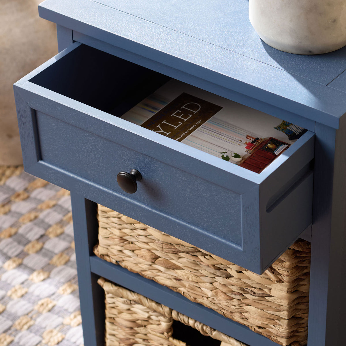 An open blue drawer offers handy storage above natural woven baskets.