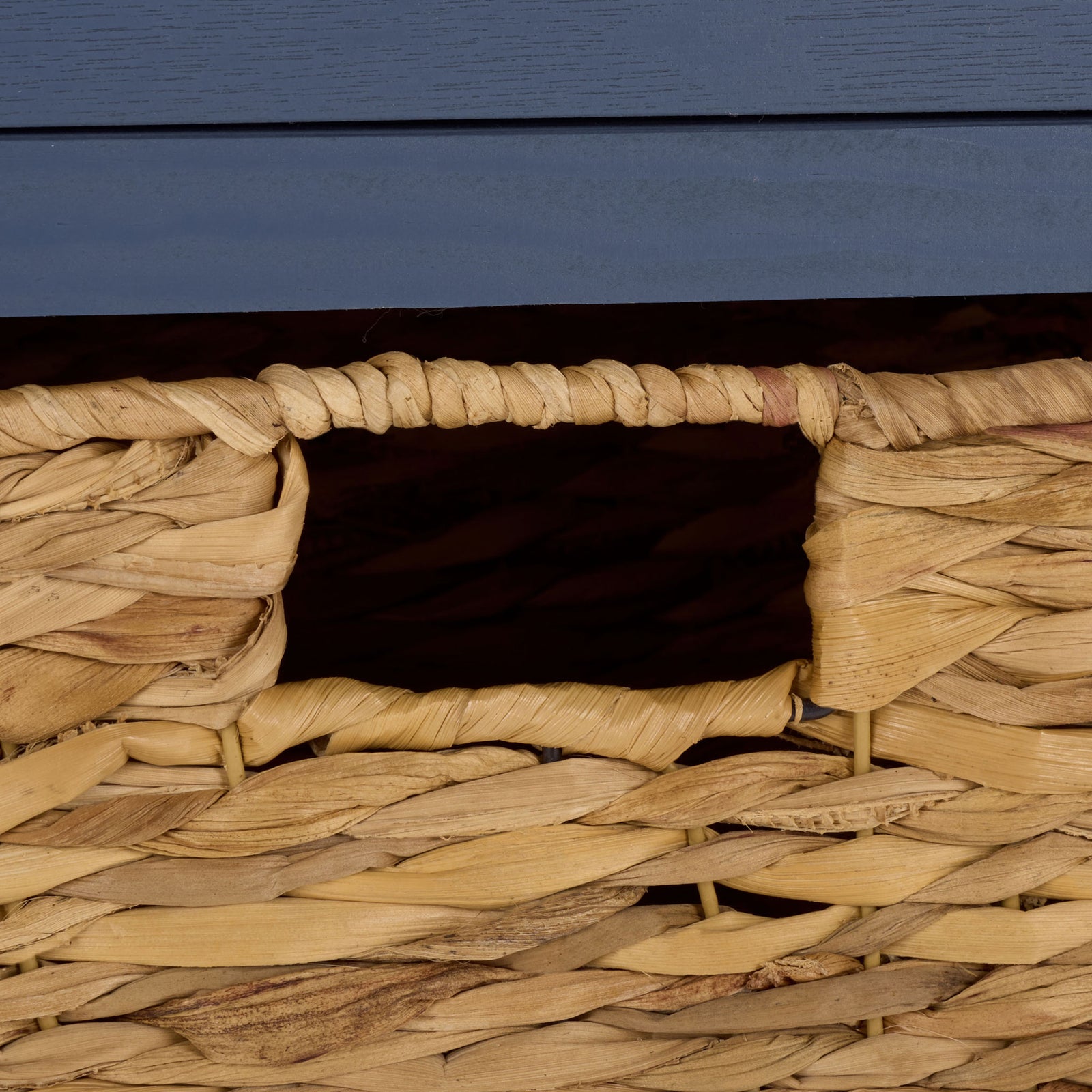 A natural woven basket features an easy-grip opening against the blue wood frame. || AMH5700K || handle_studio