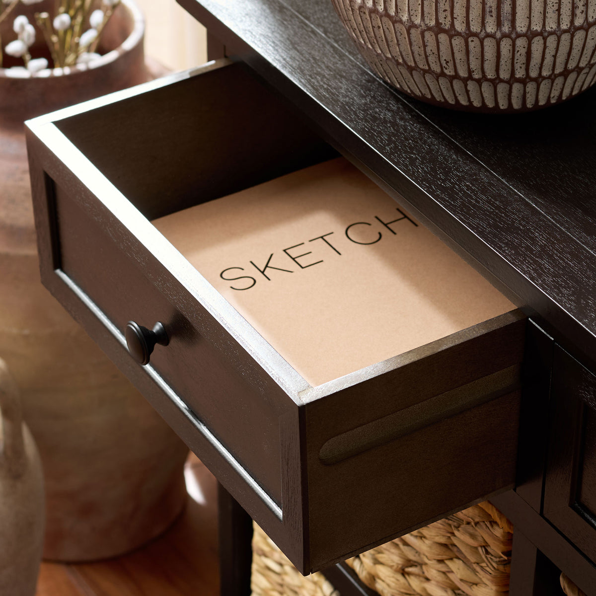 An open dark brown drawer provides extra storage above the natural woven baskets. || AMH5702H || storage_open_room