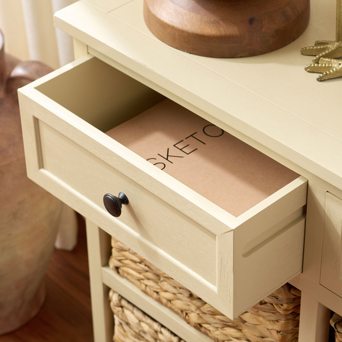 A sand-colored drawer opens wide above the cabinet's natural woven baskets. || AMH5702J || storage_open_room