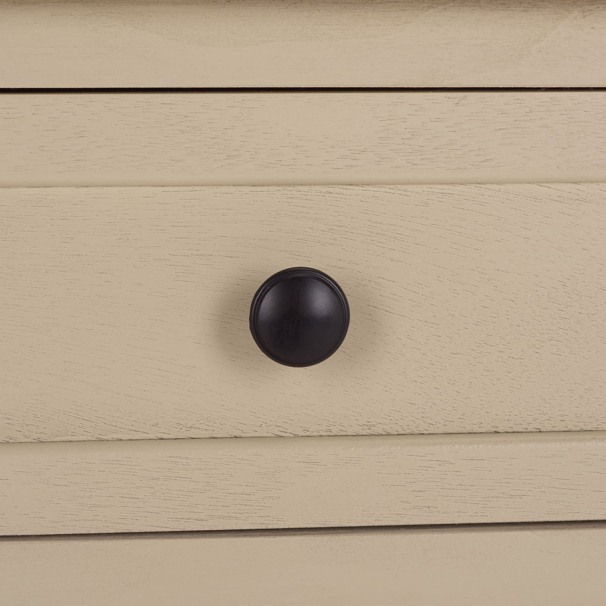 A dark round knob stands out against the sand-colored, wood-grain drawer. || AMH5702J || handle_studio