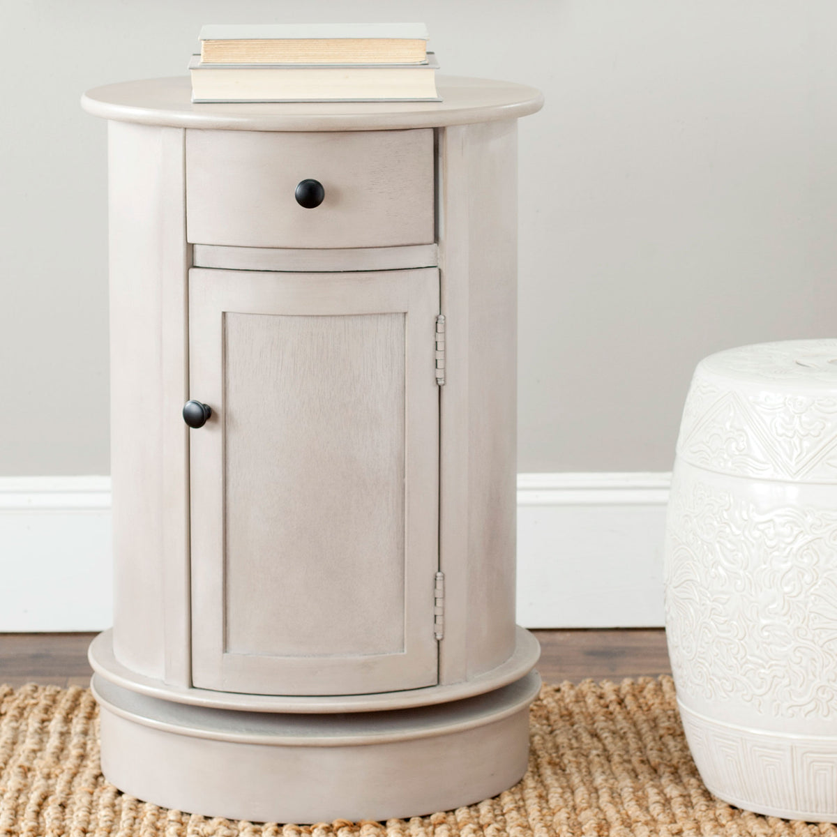 A vintage gray storage table with a round top sits beside a textured white stool || AMH5712A || front_room