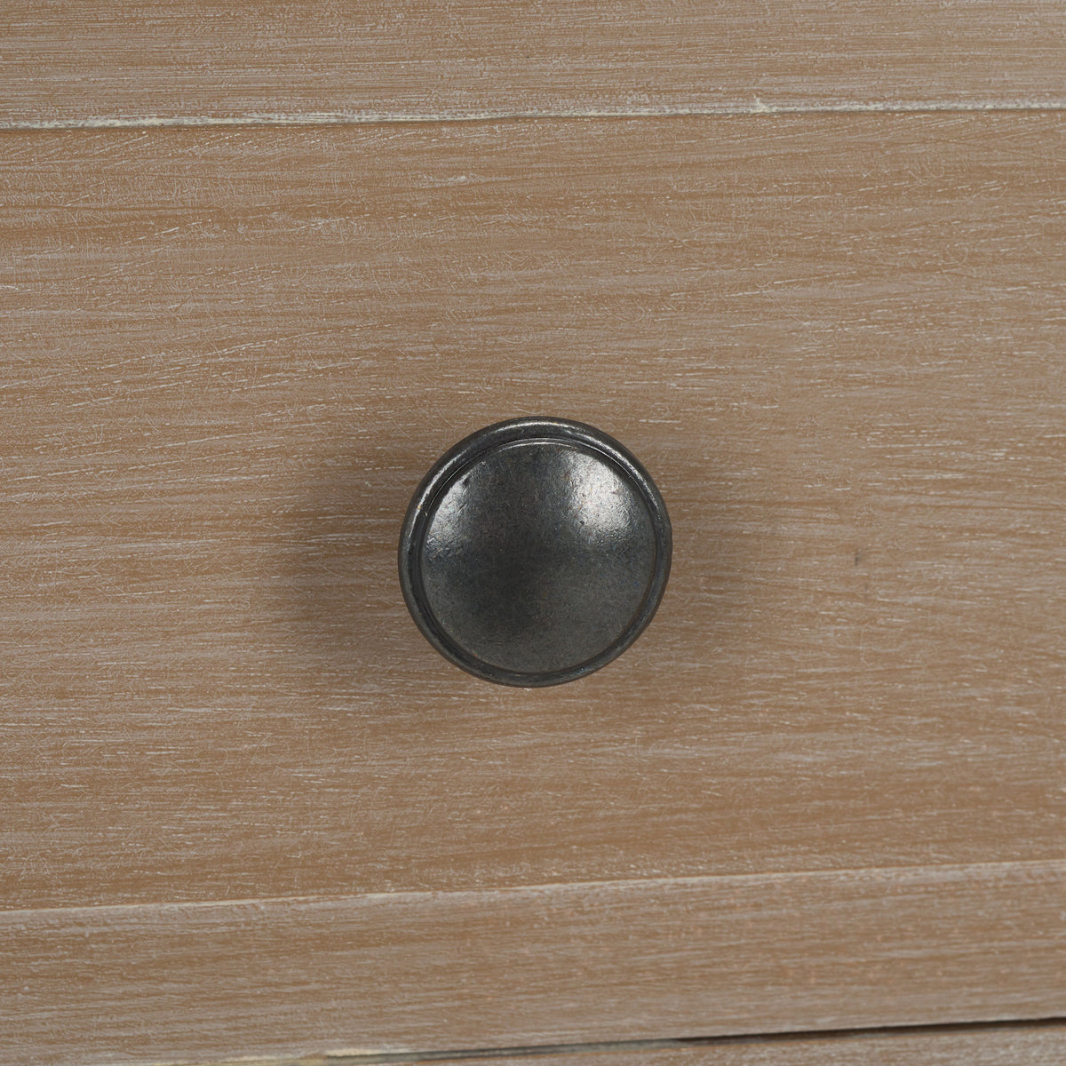 A round dark metal knob contrasts with the softly washed wood drawer front. || AMH5743E || handle_studio