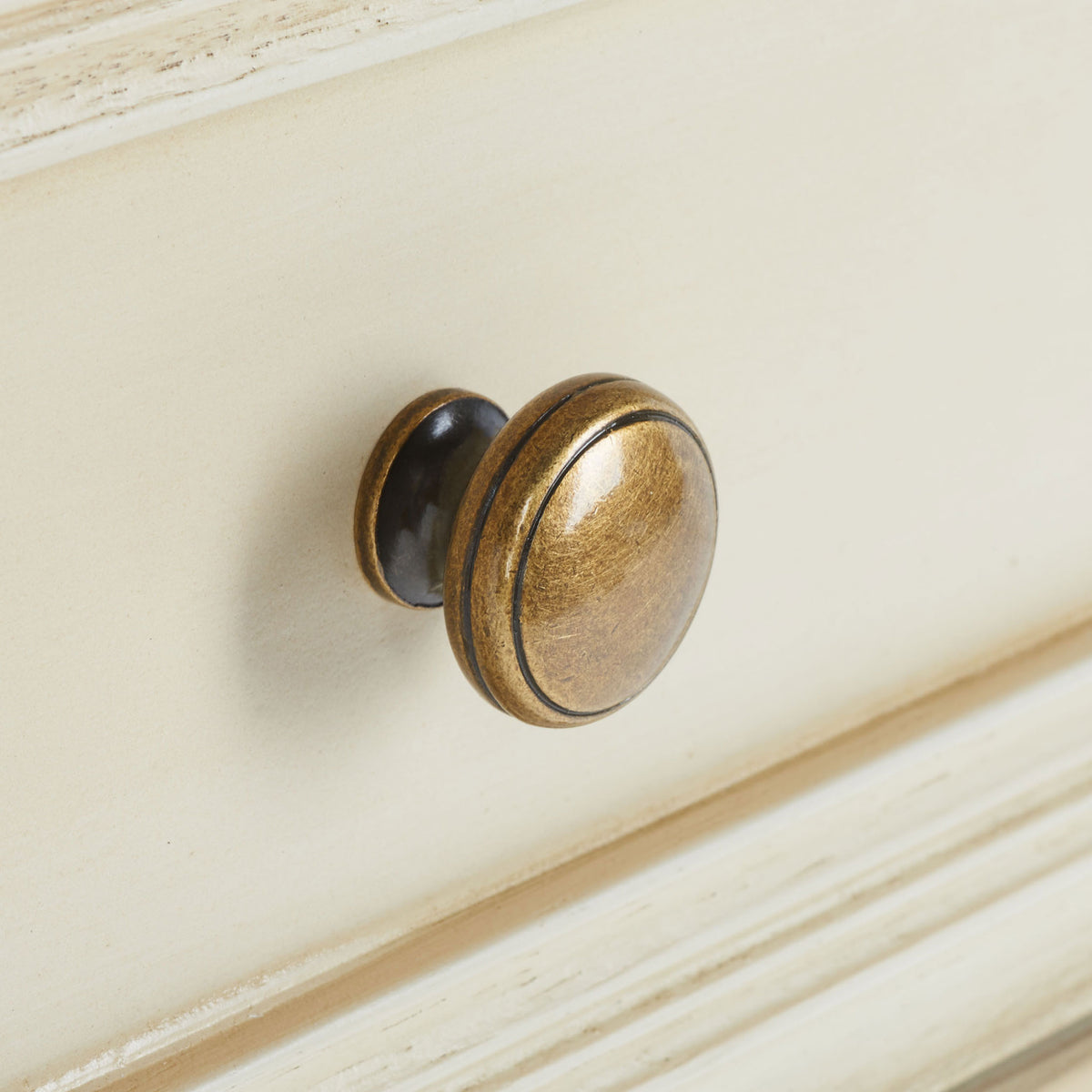 Antique gold-tone knob adds warmth to a softly distressed drawer front || AMH6627D || handle_studio