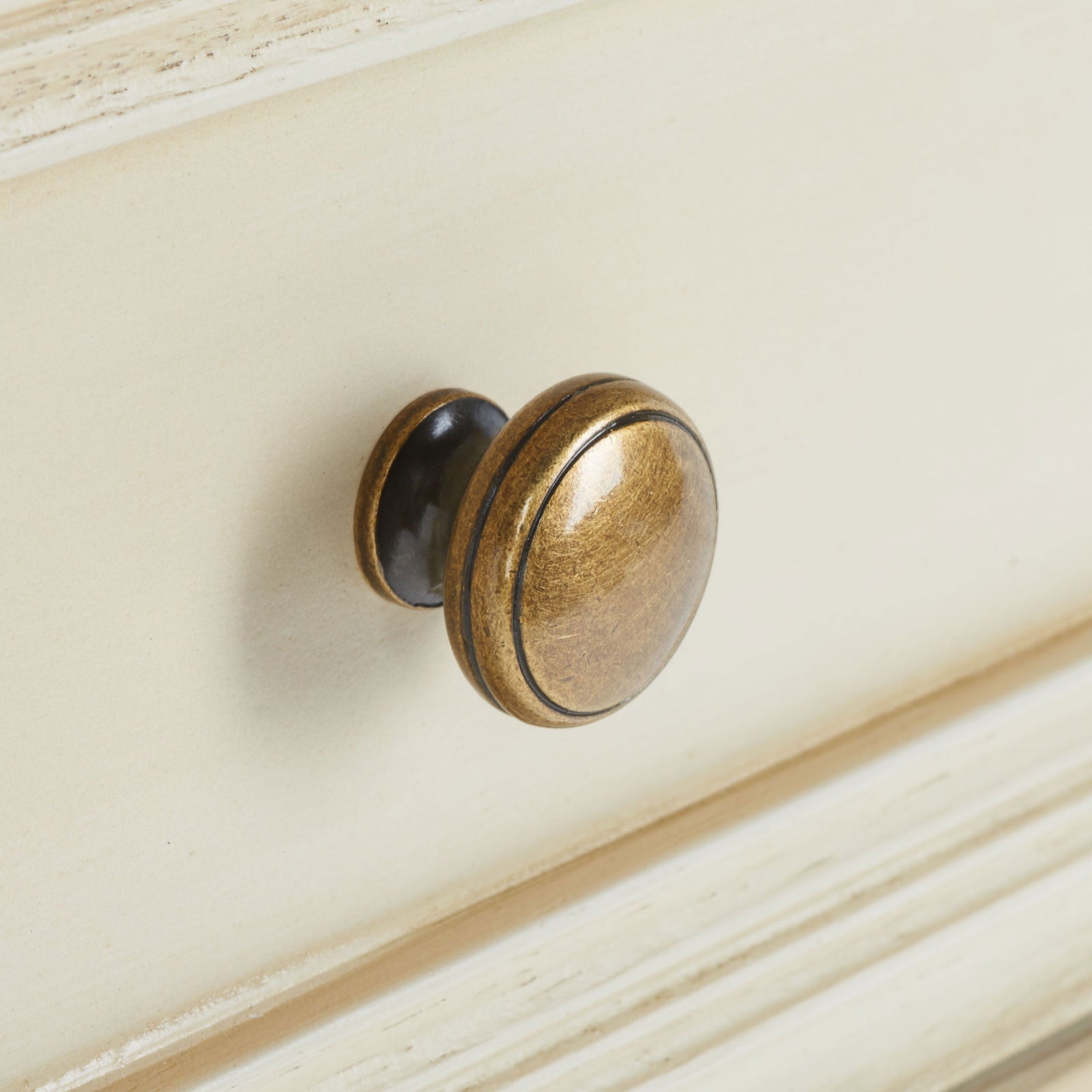 Antique gold-tone knob adds warmth to a softly distressed drawer front || AMH6627D || handle_studio