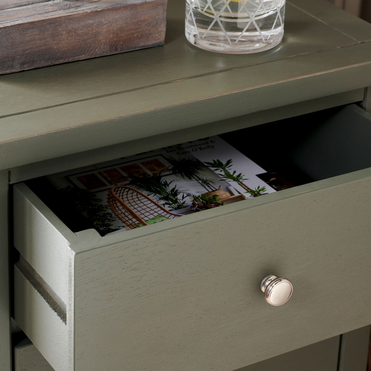 An open drawer holds reading material beneath the ash gray wood tabletop. || AMH6628A || storage_open_room