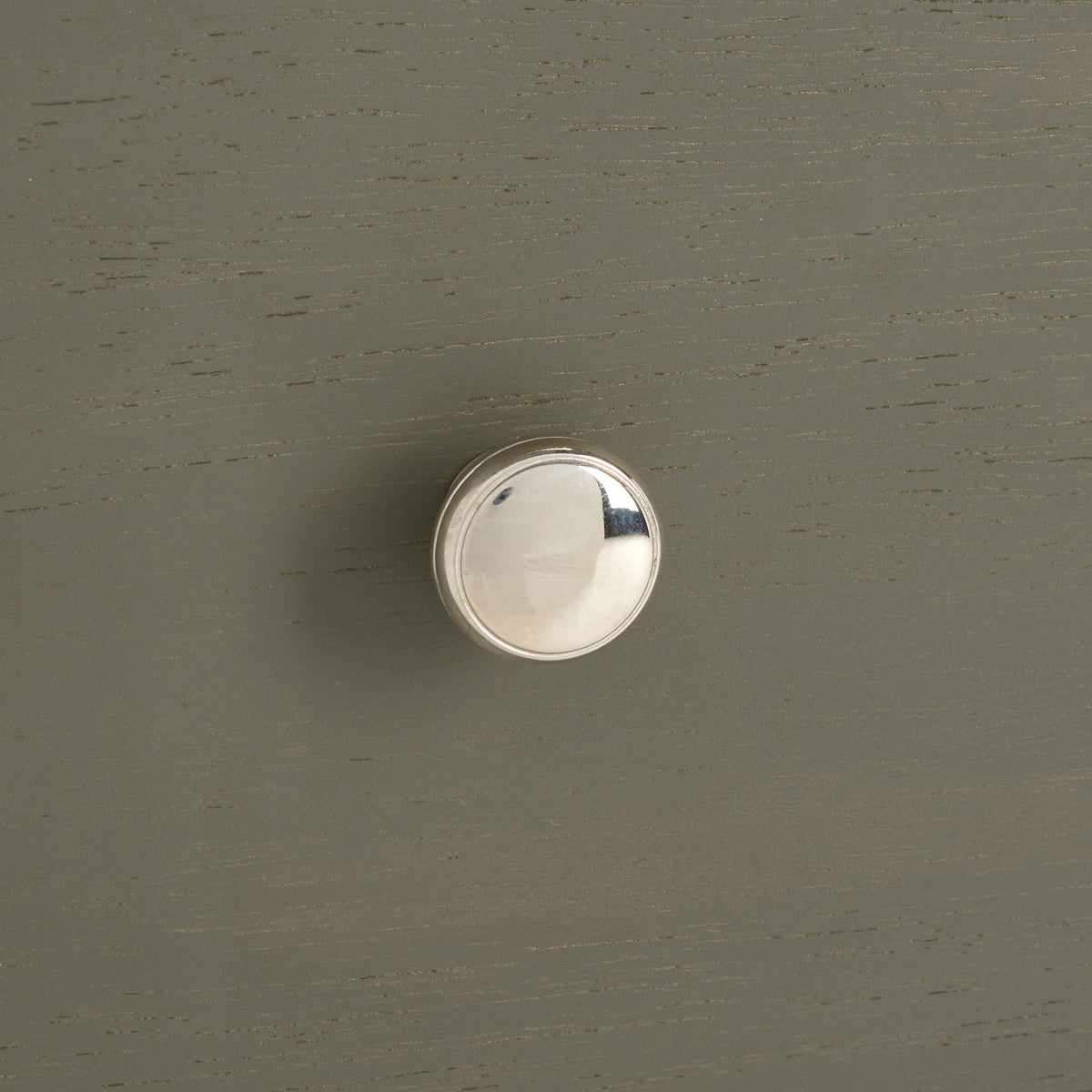 A polished silver knob adds a bright accent to the softly grained ash gray drawer front. || AMH6628A || handle_studio