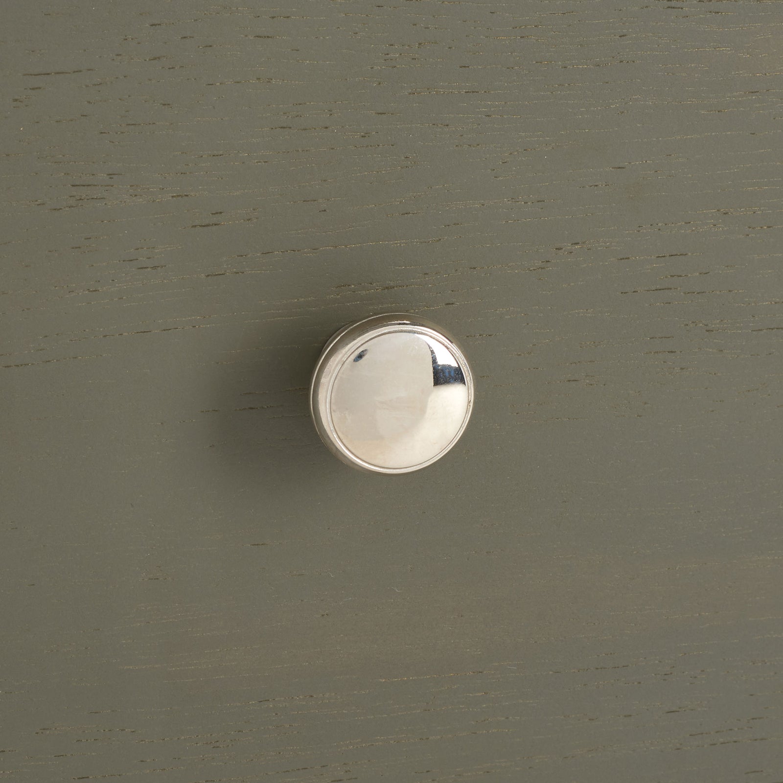 A polished silver knob adds a bright accent to the softly grained ash gray drawer front. || AMH6628A || handle_studio