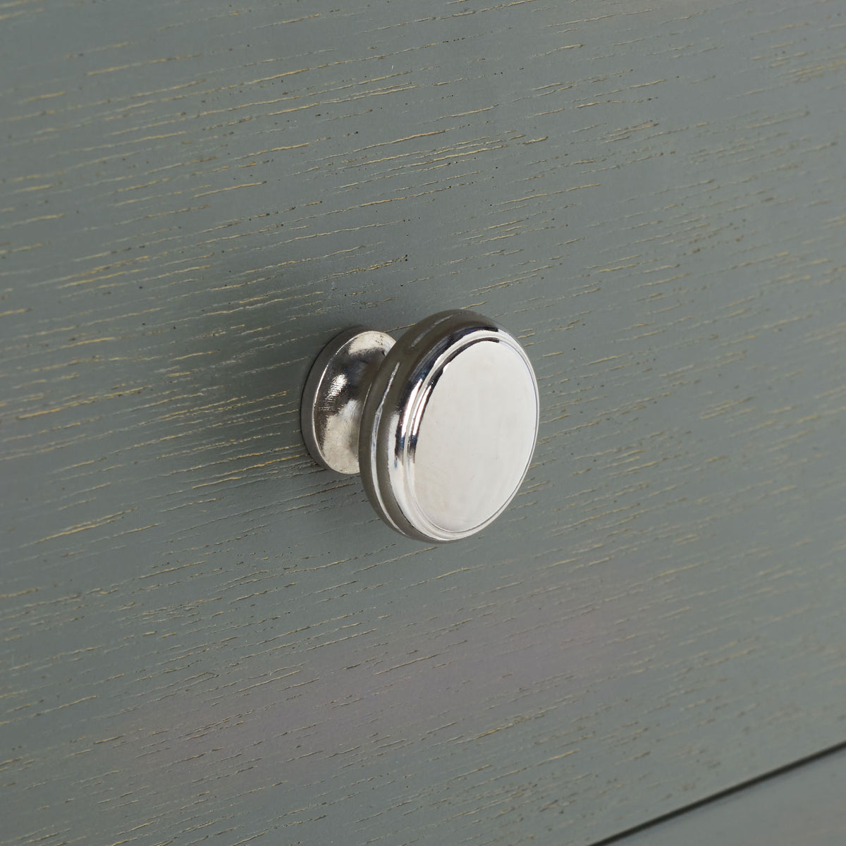 A polished silver knob adds crisp contrast to the gently textured gray drawer front. || AMH6629A || handle_studio