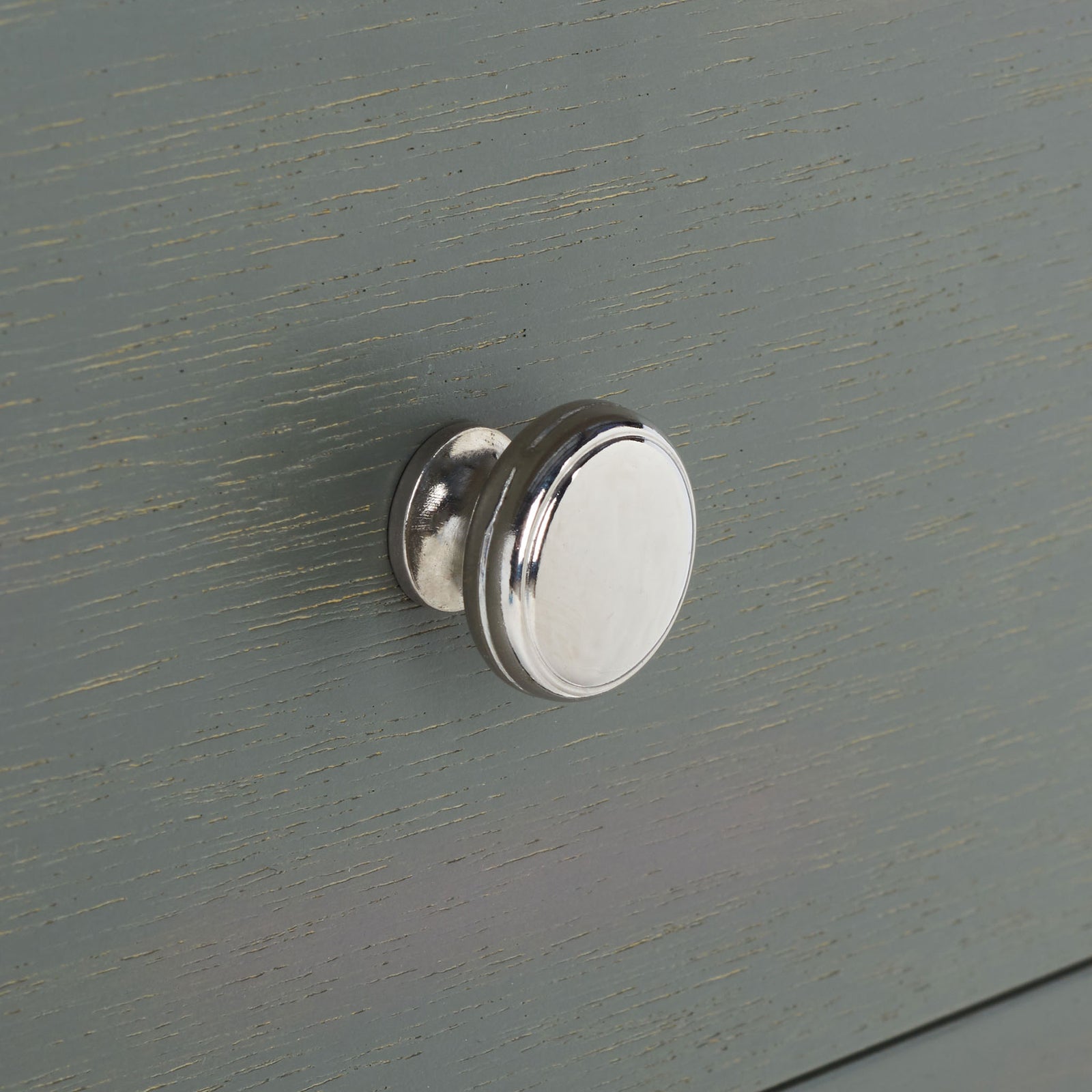 A polished silver knob adds crisp contrast to the gently textured gray drawer front. || AMH6629A || handle_studio