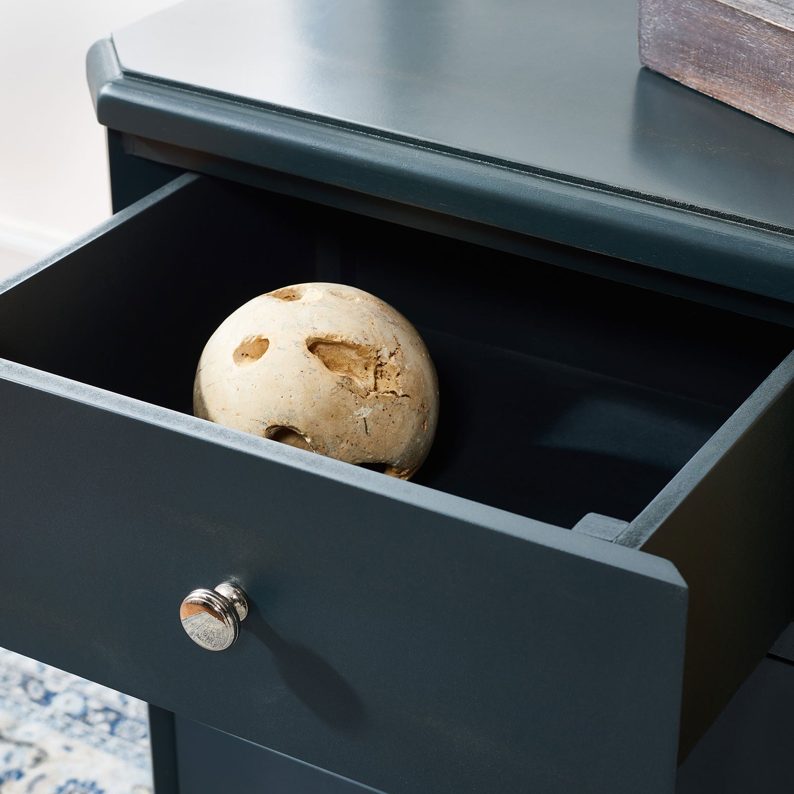 An open drawer in dark teal wood keeps small treasures close with a shiny silver knob. || AMH6629B || storage_open_room