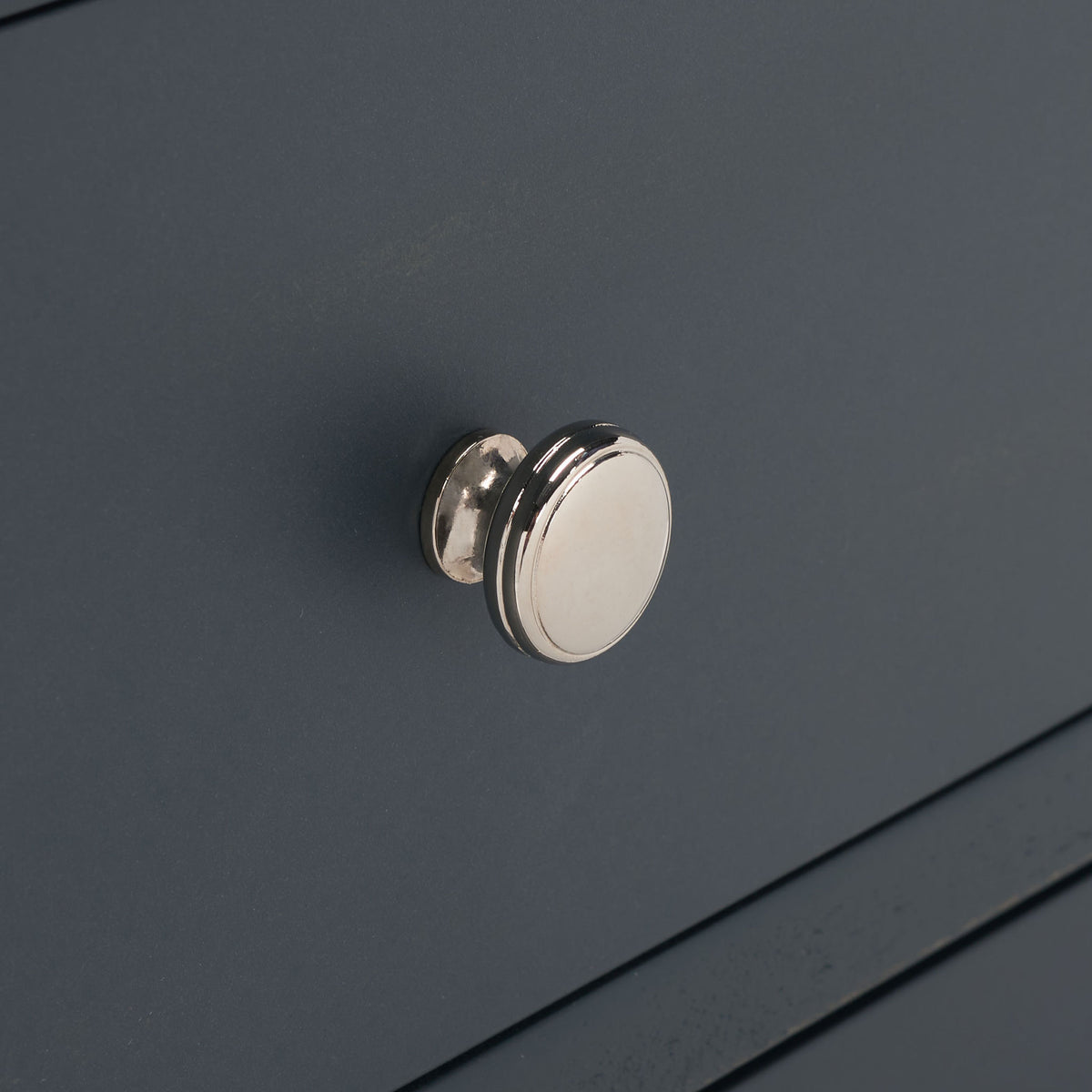 A bright silver knob punctuates the smooth dark teal drawer face. || AMH6629B || handle_studio