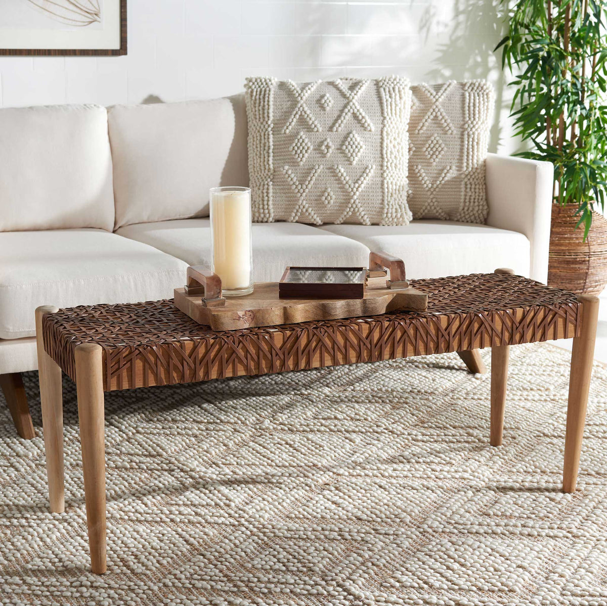 Honey-brown woven leather and teak add warmth in front of a cream sofa.