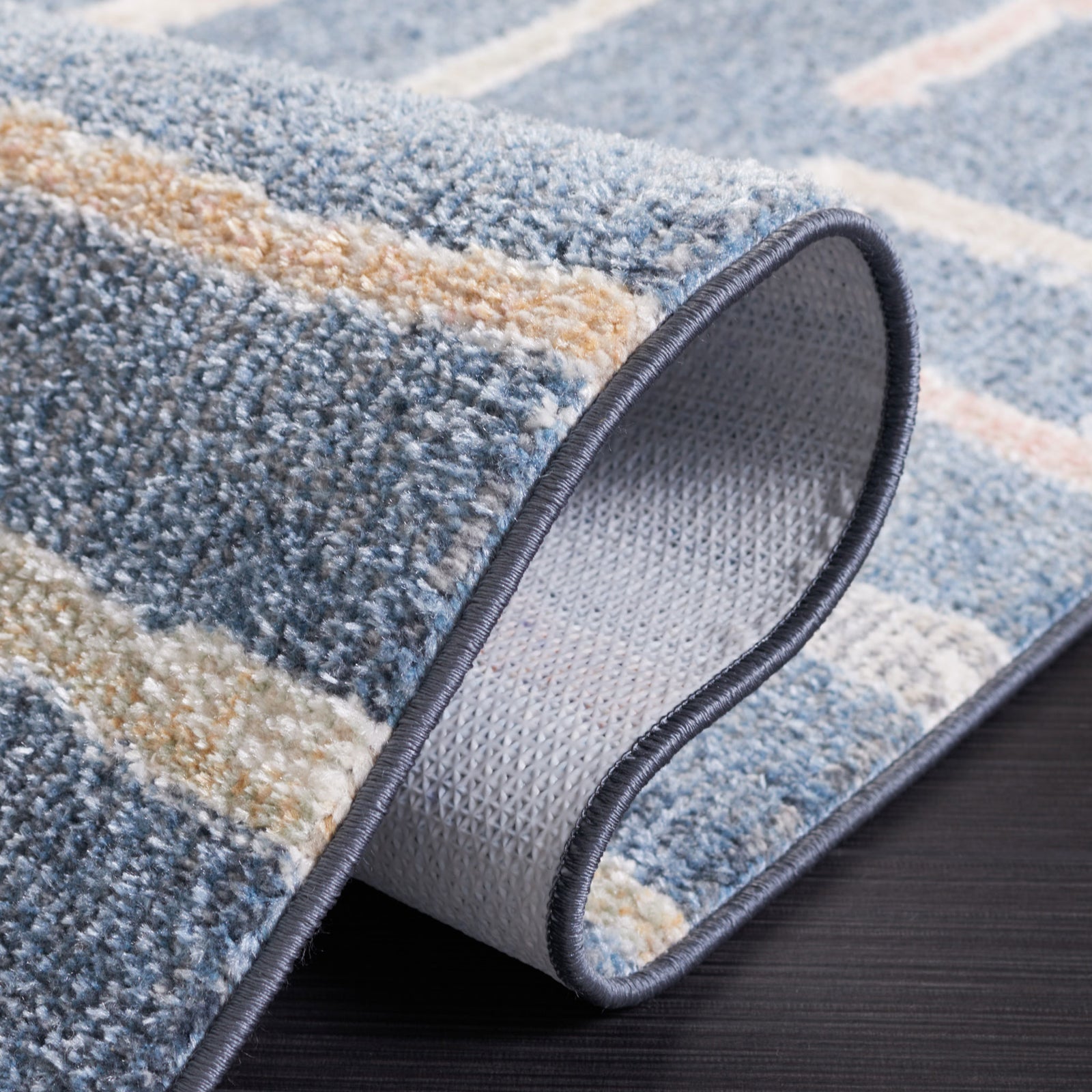 Folded rug revealing dotted backing and blue multi-color striped pattern || BLR222M-5 || backing_studio