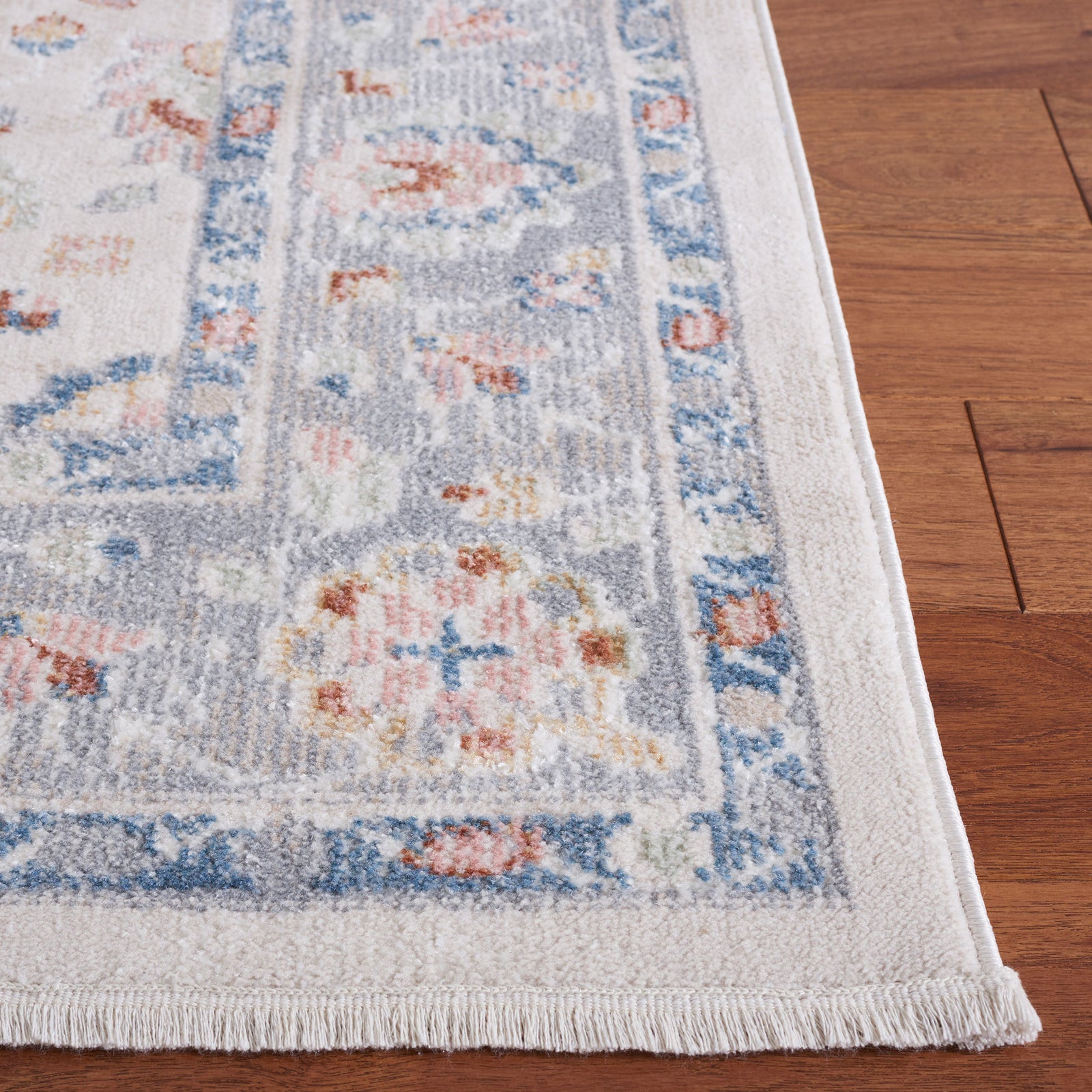Soft beige and gray rug with blue border and gently distressed floral pattern. || BLR224B-5 || top_studio